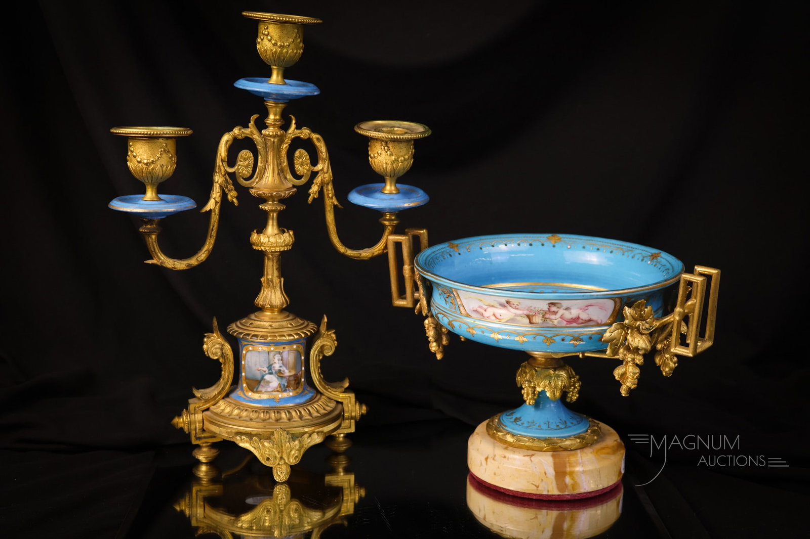 2 pc Lot Sevres Ormolu Mounted Porcelain: Two distinct finds in French Sevres ormolu-mounted porcelain. The first piece is a compote with a cherub scene and a grape-adorned ormolu. This piece sits on a marble base. The second is a three-armed