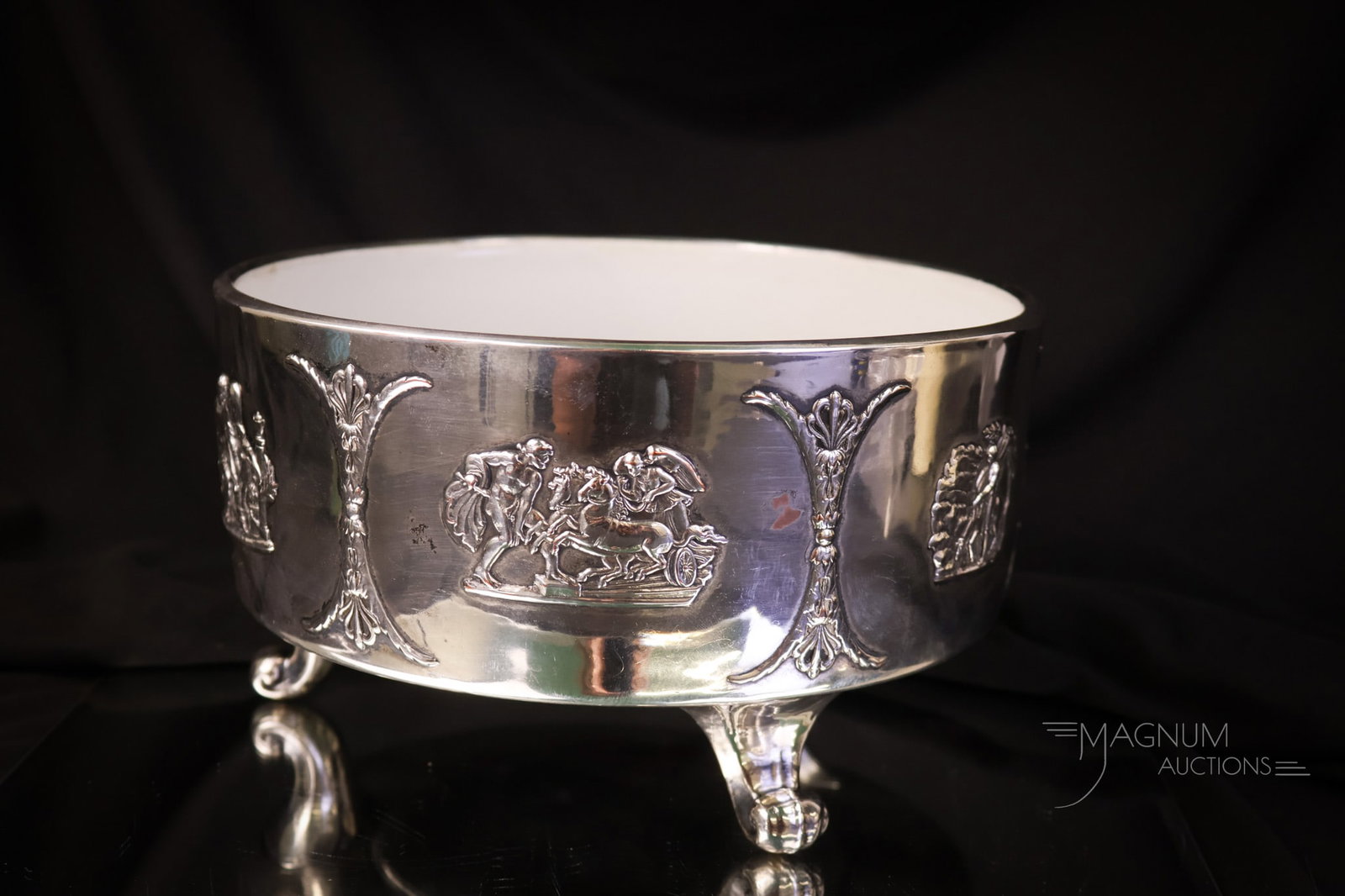 Wedgwood Sterling Silver Clad 8 1/2" Bowl: An unusual and beautiful Wedgwood sterling silver-clad bowl. The bowl features three feet and different scenes around the body. Crazing is present. The bowl measures 5" tall and 8 1/2" in diameter. SH