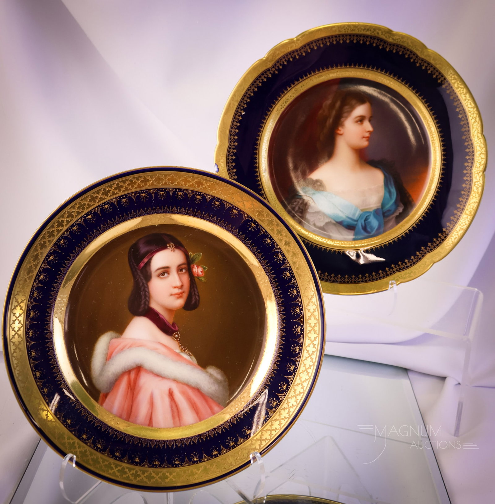 2 pc Lot Royal Vienna Porcelain Artist Signed Portrait Plates: Two beautiful Royal Vienna hand-painted porcelain cobalt and gold portrait plates. Each is artist-signed. The first is of Elisabeth, Empress of Austria. The second is of Lady Jaune Enskine. The first 