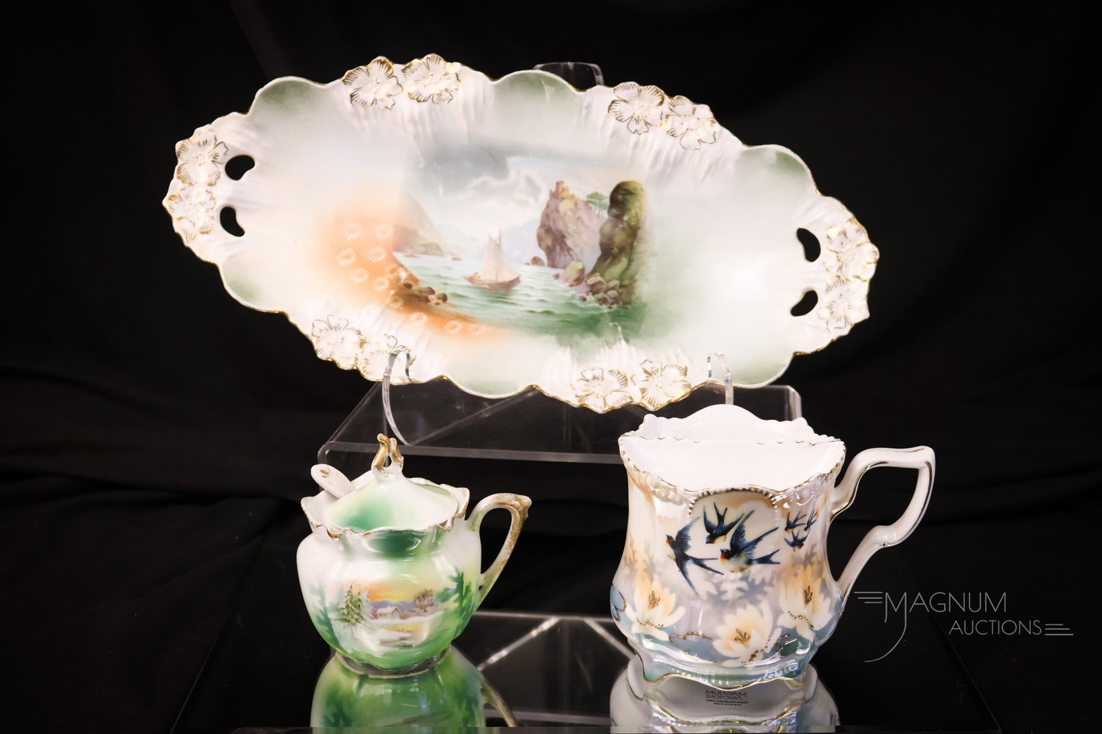 3 pc Lot R.S. Prussia Porcelain Bluebirds & More: Three fine examples of R.S. Prussia. This lot includes a "Man in the Mountain" relish dish. A "Snowbirds" scene mustard pot with spoon and lid. Lastly, there is a "Bluebirds" mustache cup. The tallest