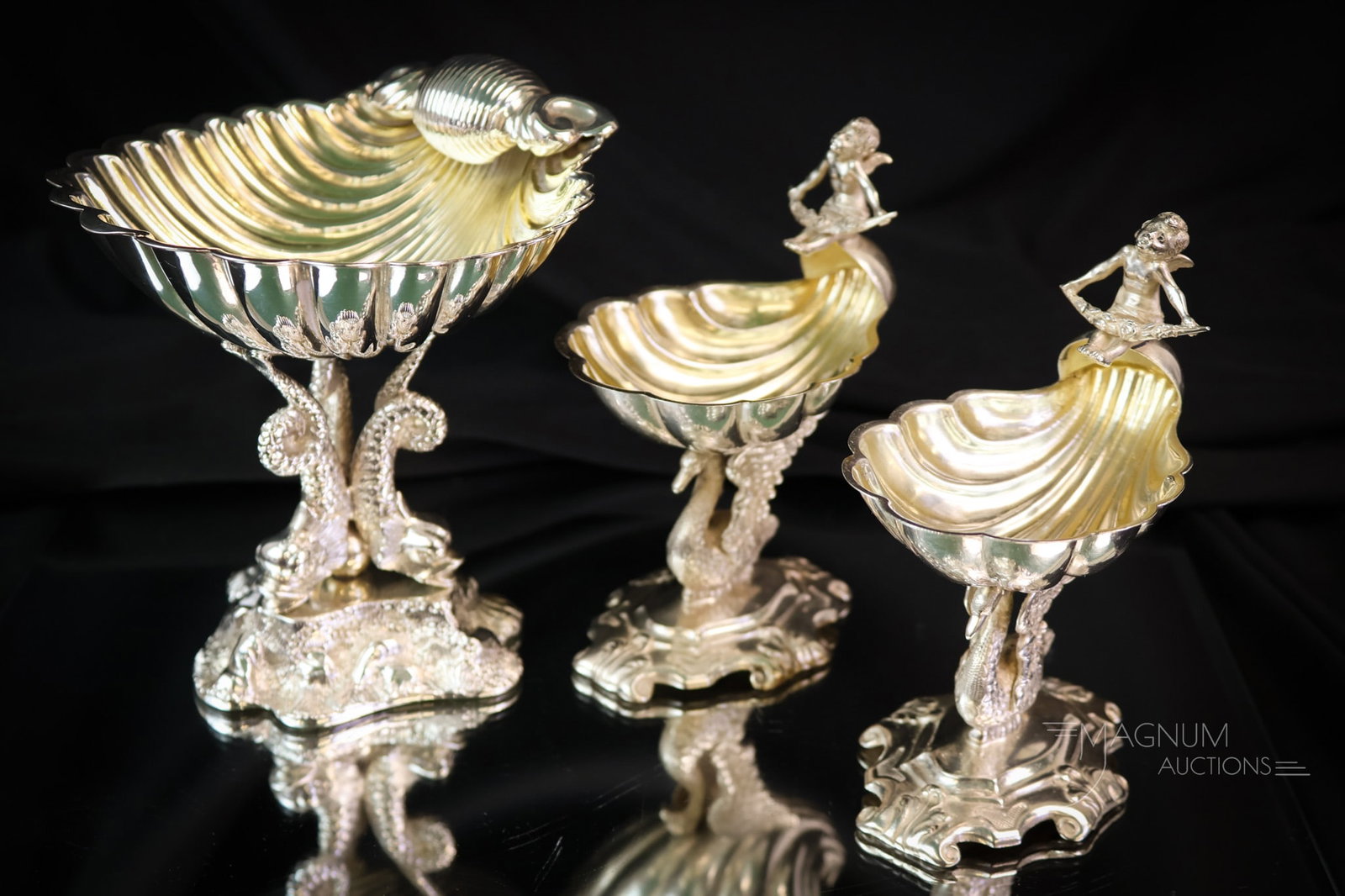 3 pc Lot Hallmarked Figural Silverplate Open Salts Master & Individual: Three attractive finds in antique hallmarked silverplate open salts. There is a master salt and two individuals. The two smaller examples exhibit swan stems and figural cherubs atop a shell-form bowl.
