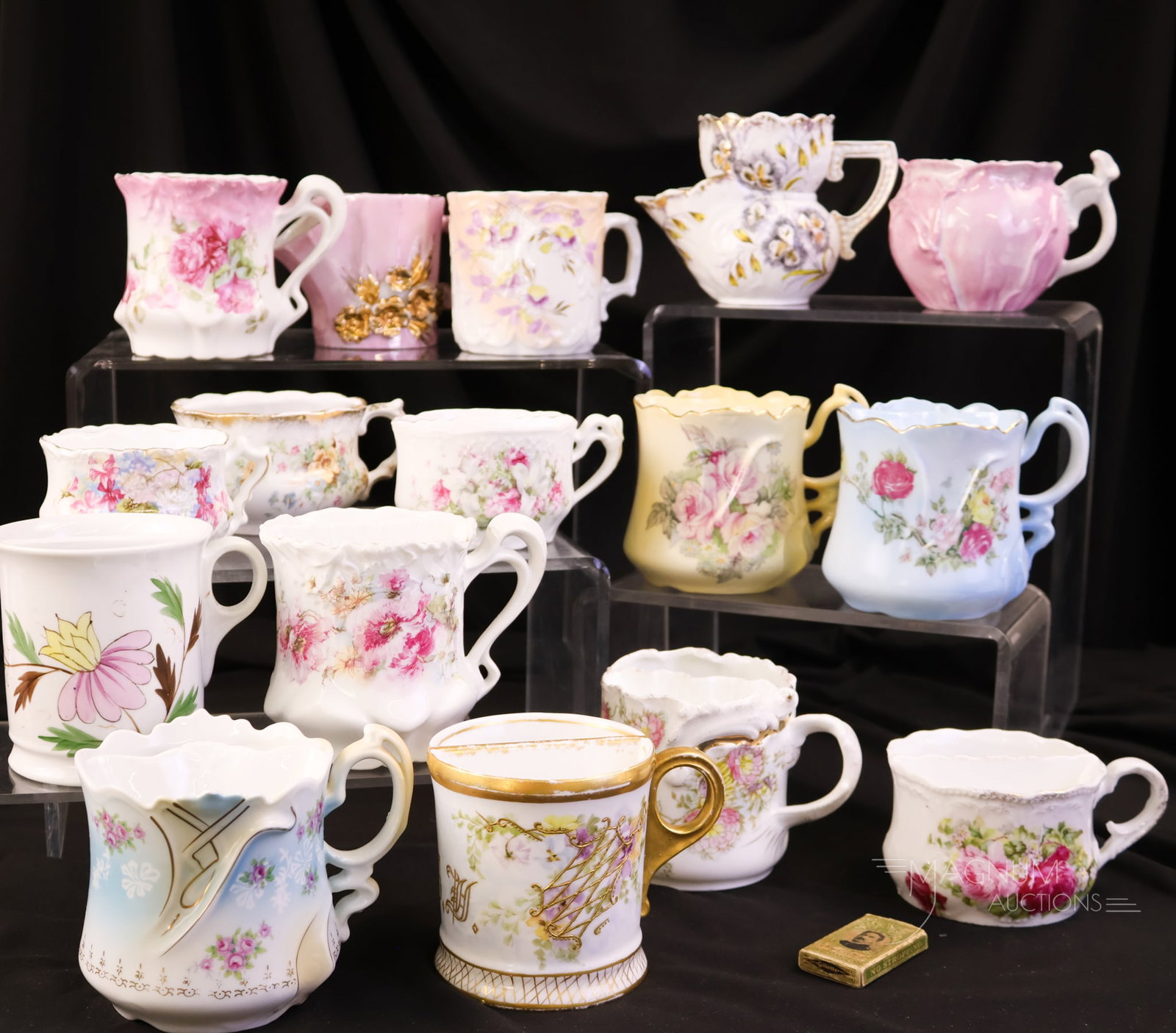 16 pc Lot Victorian Mustache Cups: A plentiful offering of sixteen Victorian mustache cups. Each is uniquely decorated with florals. The tallest measures 3 1/2".