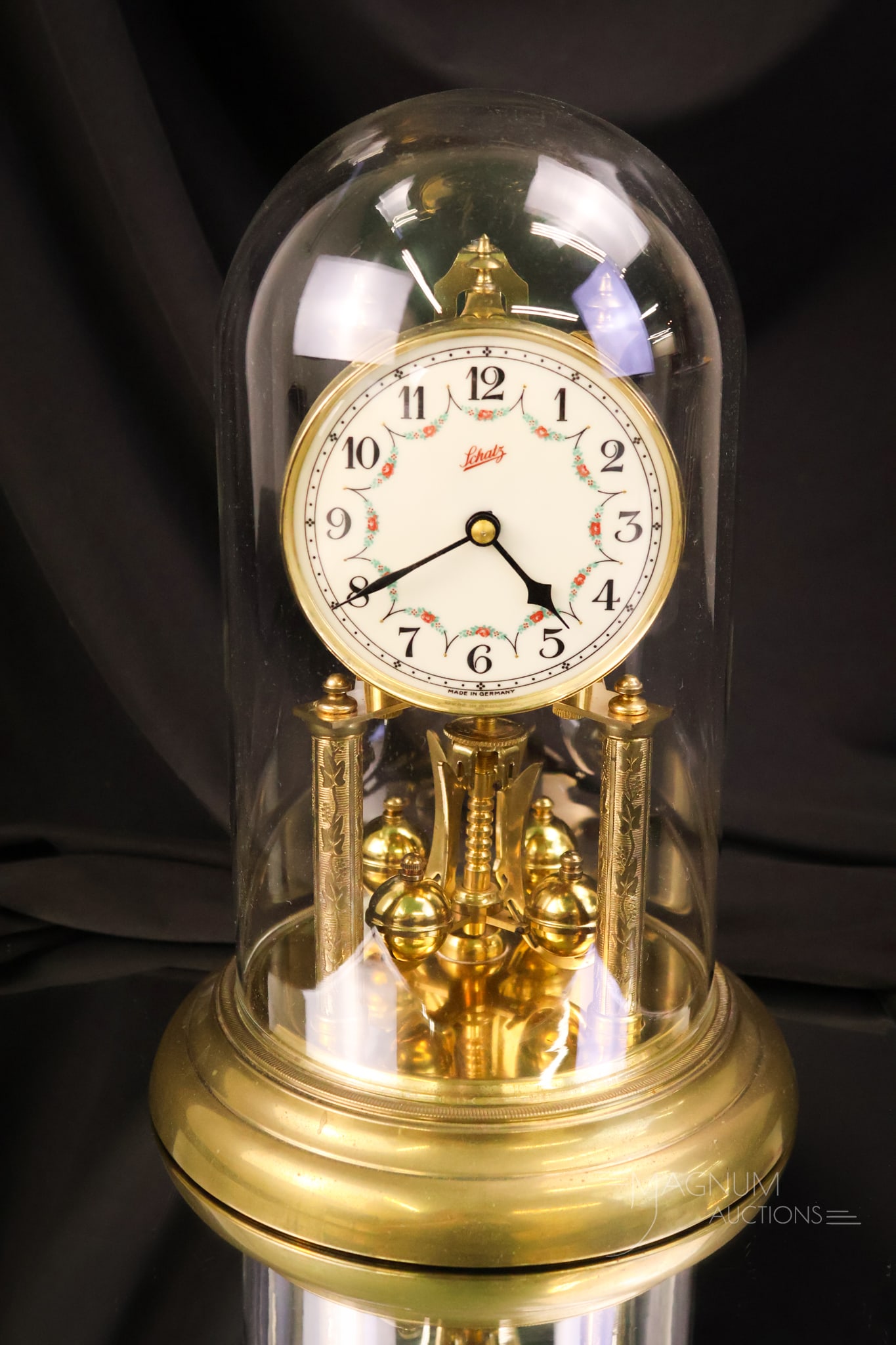 Vintage Schatz Anniversary Enameled Porcelain Clock: A beautiful vintage Schatz anniversary clock. This beautiful piece features an enameled porcelain dial in red and blue, with floral garlands. The clock features a ball pendulum and is complete with a
