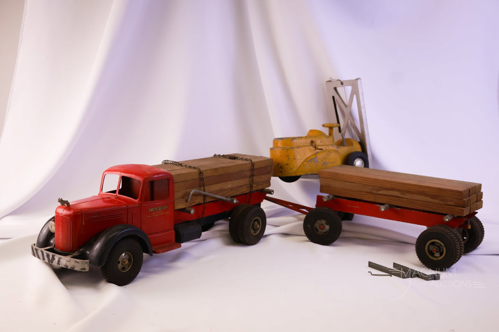Vintage Toy Lot Smith-Miller Logging Truck & Trailer & More: A lot of Vintage toys, including a Smith-Miller pressed steel logging track with trailer. The lot includes a "Scientific Toys" "Little Giant" lift truck. The tallest measures 6 1/2" and 19" wide. The