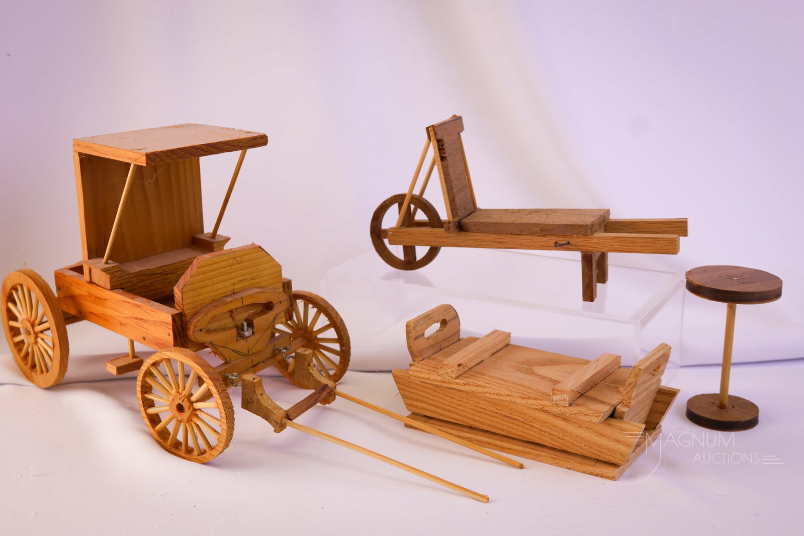 4 pc Lot Handmade Wooden Toys: A charming offering of handmade wooden toys. The lot offers a wheelbarrow, a coffin, a wagon, and a table. The tallest measures 6 1/4".
