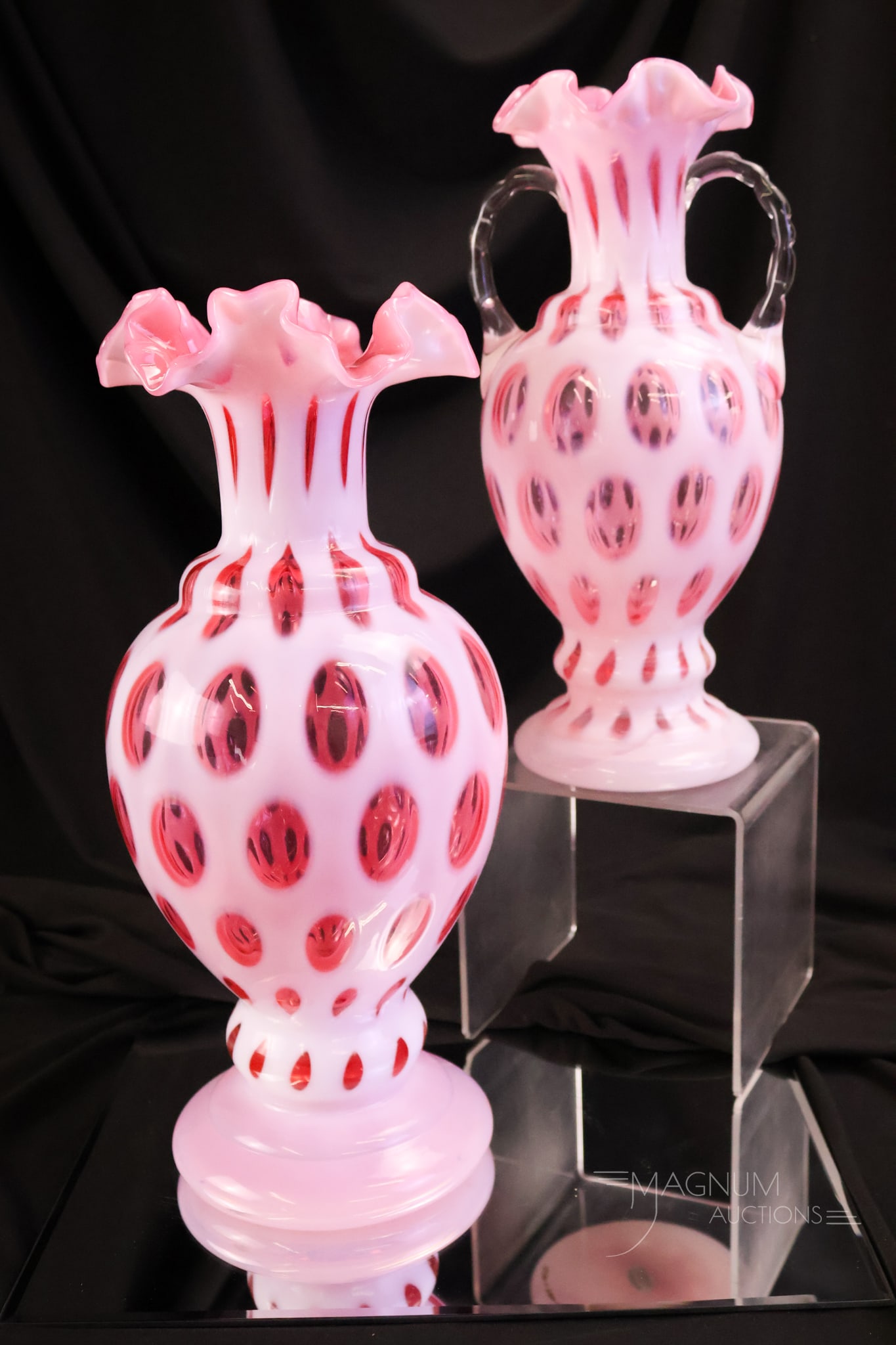 2 pc Lot Fenton Cranberry Opalescent Art Glass Coin Dot Vases: Two fine cranberry opalescent art glass Fenton vases. The first is a rare example in the largest size, made with a ruffled rim. The second is a scarce two-handled example. The tallest measures 13".