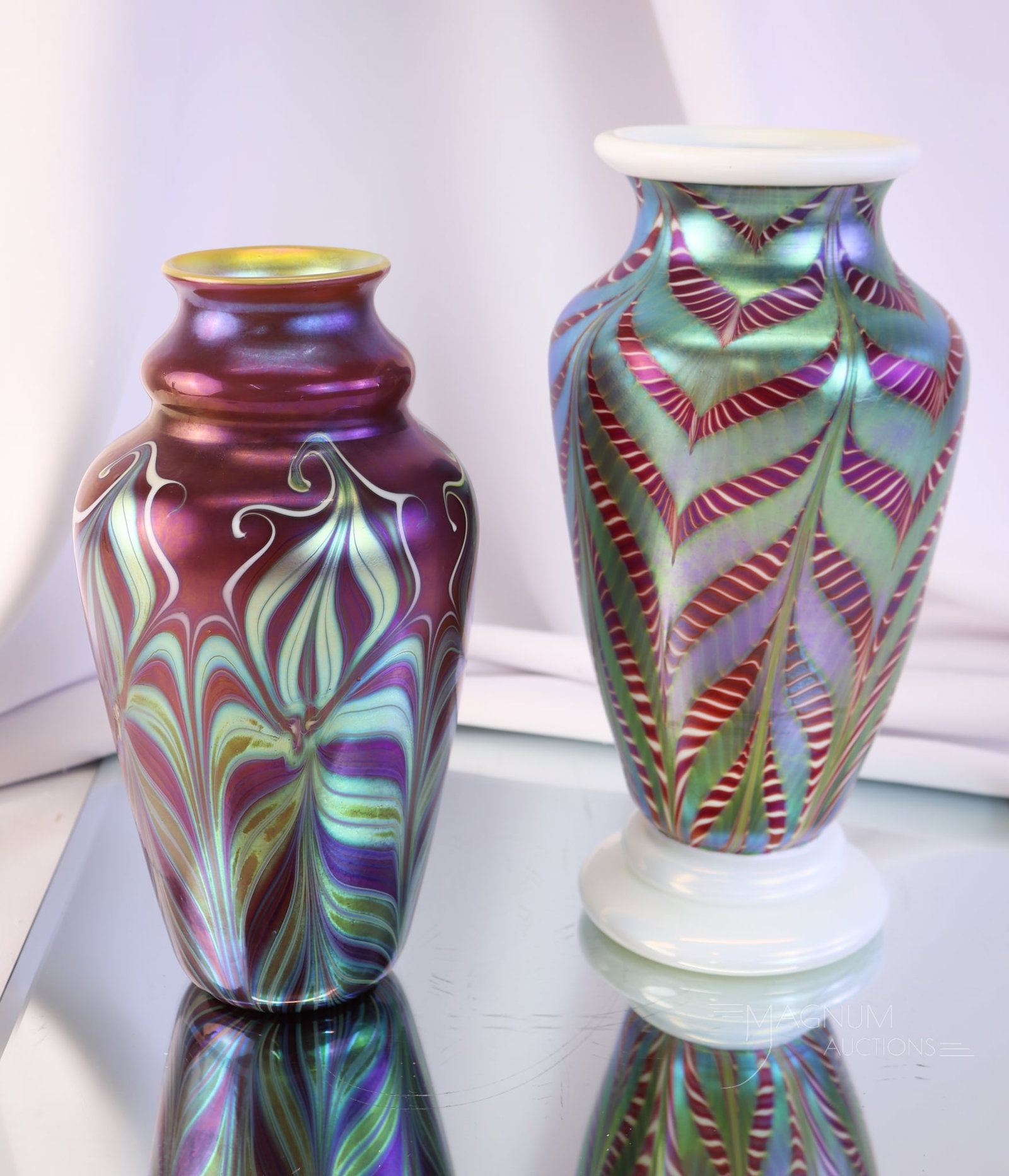 2 pc Lot Signed Orient & Flume Art Glass Vases: A two-piece lot of signed Orient & Flume art glass vases. The first is an electric blue with maroon pulled feather. The second example is a blue pulled feather over red with an applied opal glass rim 