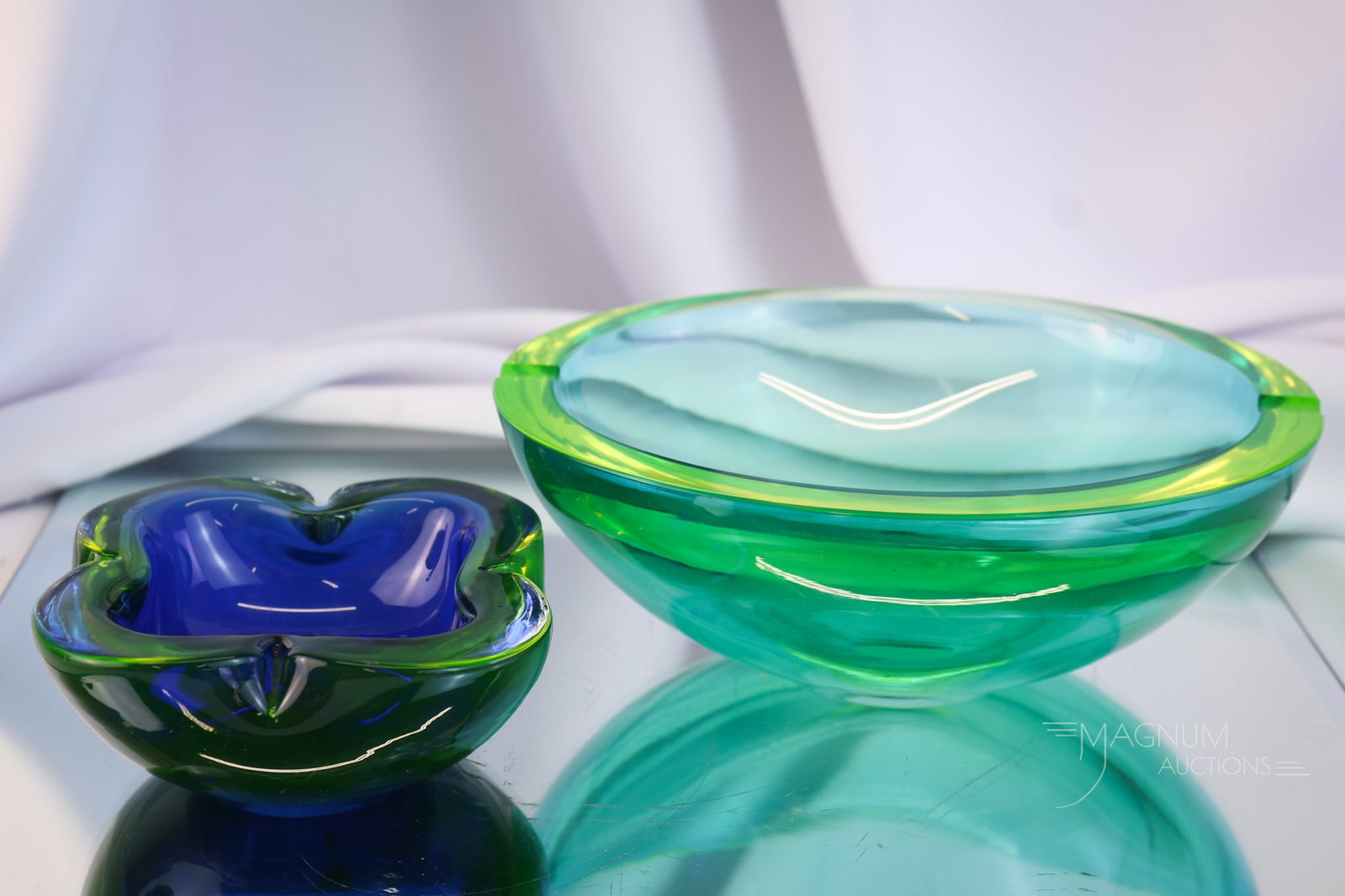 2 pc Lot Italian Murano Sommerso Uranium Art Glass Ashtrays: Two wonderful finds in Italian Murano Sommerso uranium-rich art glass ashtrays. The first is a large geode-style ashtray with aqua coloring. The second is a smaller example in a square shape and is