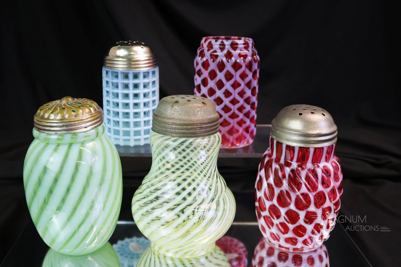 5 pc Lot Victorian Opalescent Glass Sugar Shakers Uranium & More: A plentiful assortment of Victorian opalescent glass sugar shakers. The lot includes a blue Beatty Waffle, a green opal Swirl, a cranberry Ribbed Opal Lattice without lid, a cranberry opalescent