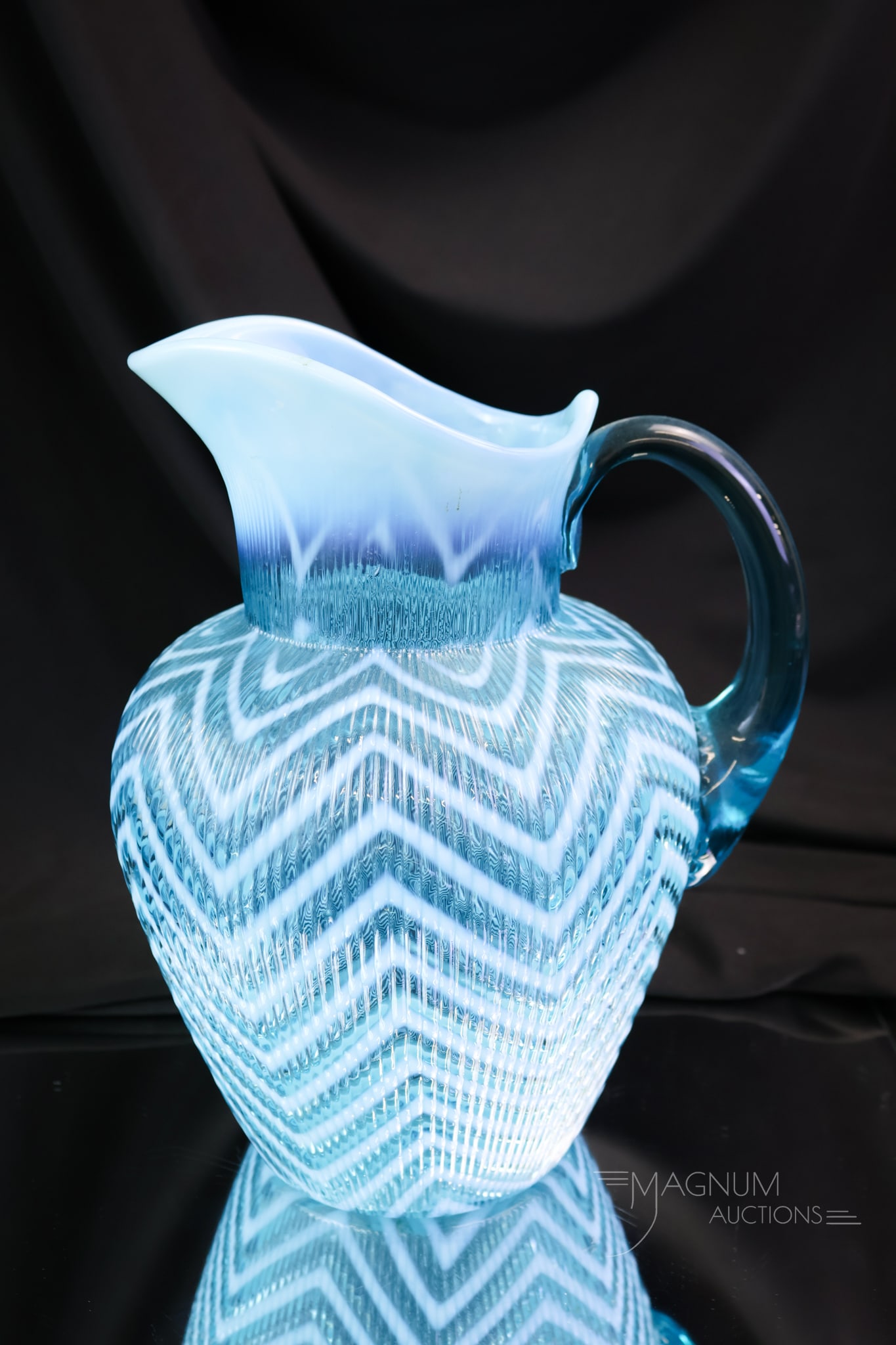 Northwood Ribbed Herringbone Blue Opalescent Victorian Glass Water Pitcher: A striking example of a Northwood Ribbed Herringbone Victorian opalescent blue water pitcher. This one has a lovely blue color and bold opalescence.The pitcher measures 9" tall.