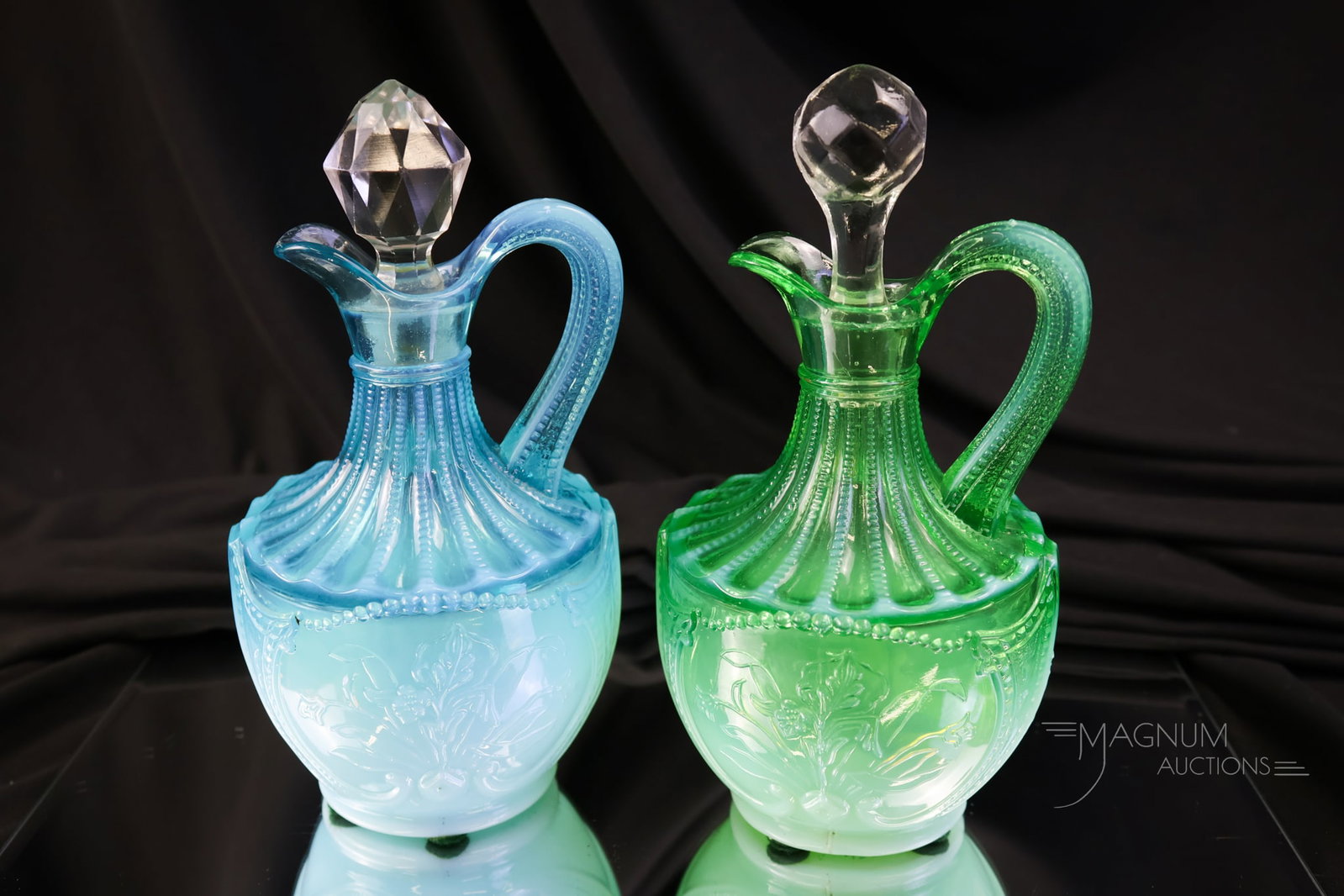 2 pc Lot Northwood Victorian Glass Wild Bouquet Cruets Uranium: Two delightful examples of Northwood Wild Bouquet opalescent pattern cruets. One cruet is in blue and one is in green. The green is rich in uranium content and glows under black light. Each measures 6
