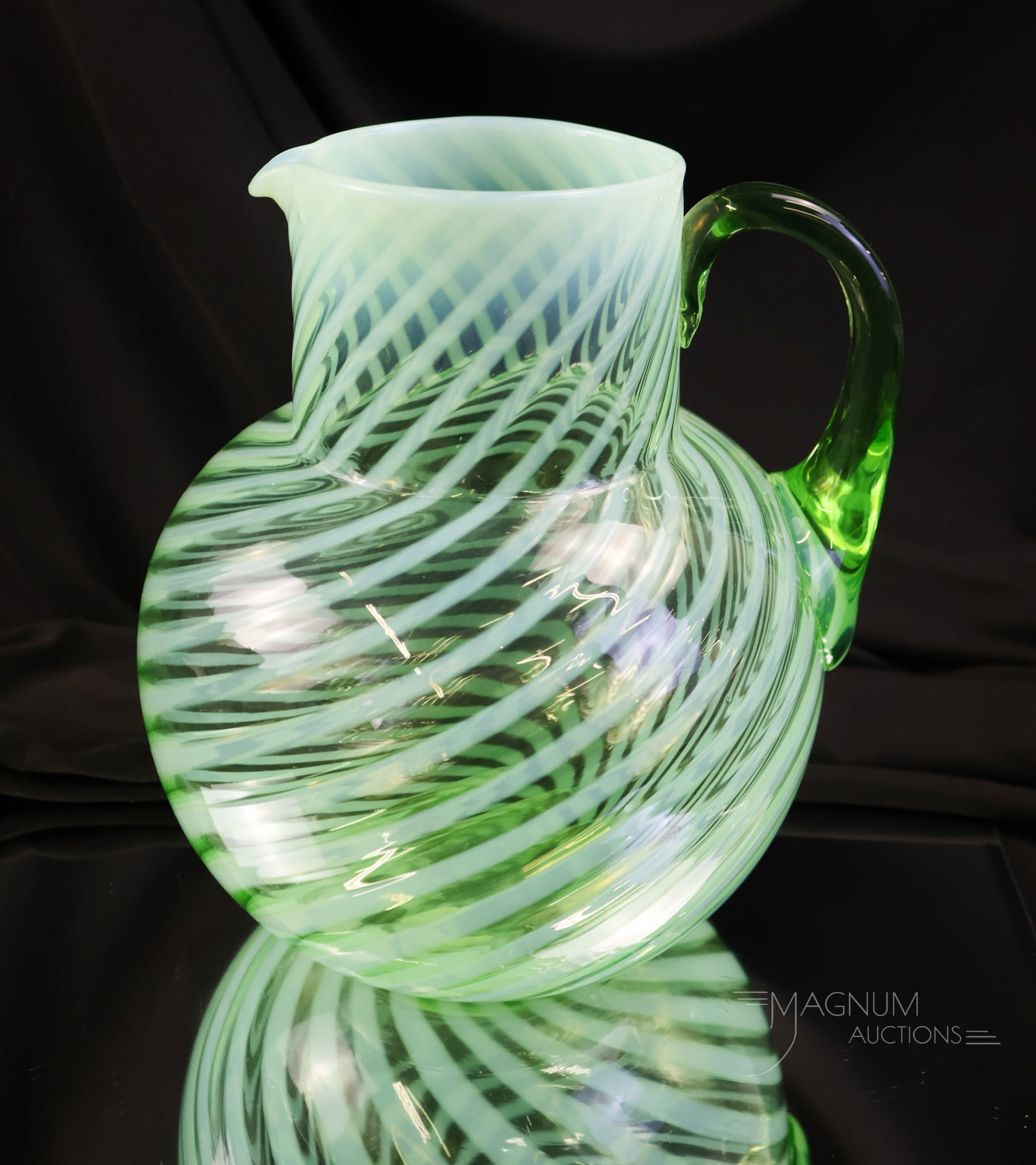 Victorian Green Uranium Opalescent Glass Water Pitcher: A shining find in our auction. This is a green opalescent, uranium-rich Victorian water pitcher in the Swirl pattern. This pitcher glows brightly under black light. Make way on the shelf for this one!