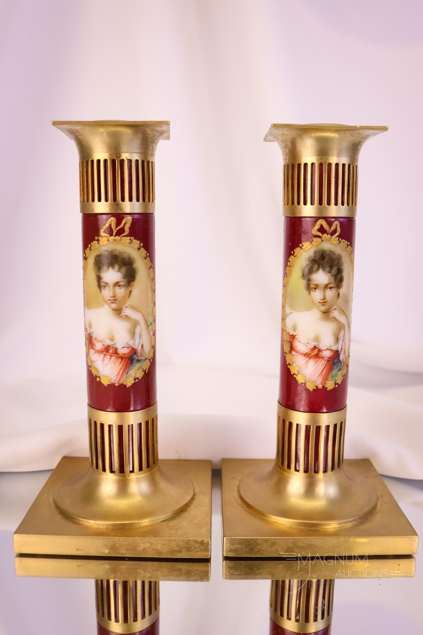 Pair of Pairpoint Portrait Painted Glass & Metal Candlesticks: A beautiful pair of marked Pairpoint glass and metal candlesticks. Each is a glass candle stem painted with a matching portrait of a young woman. The candle cup top and base are removable. Each measur