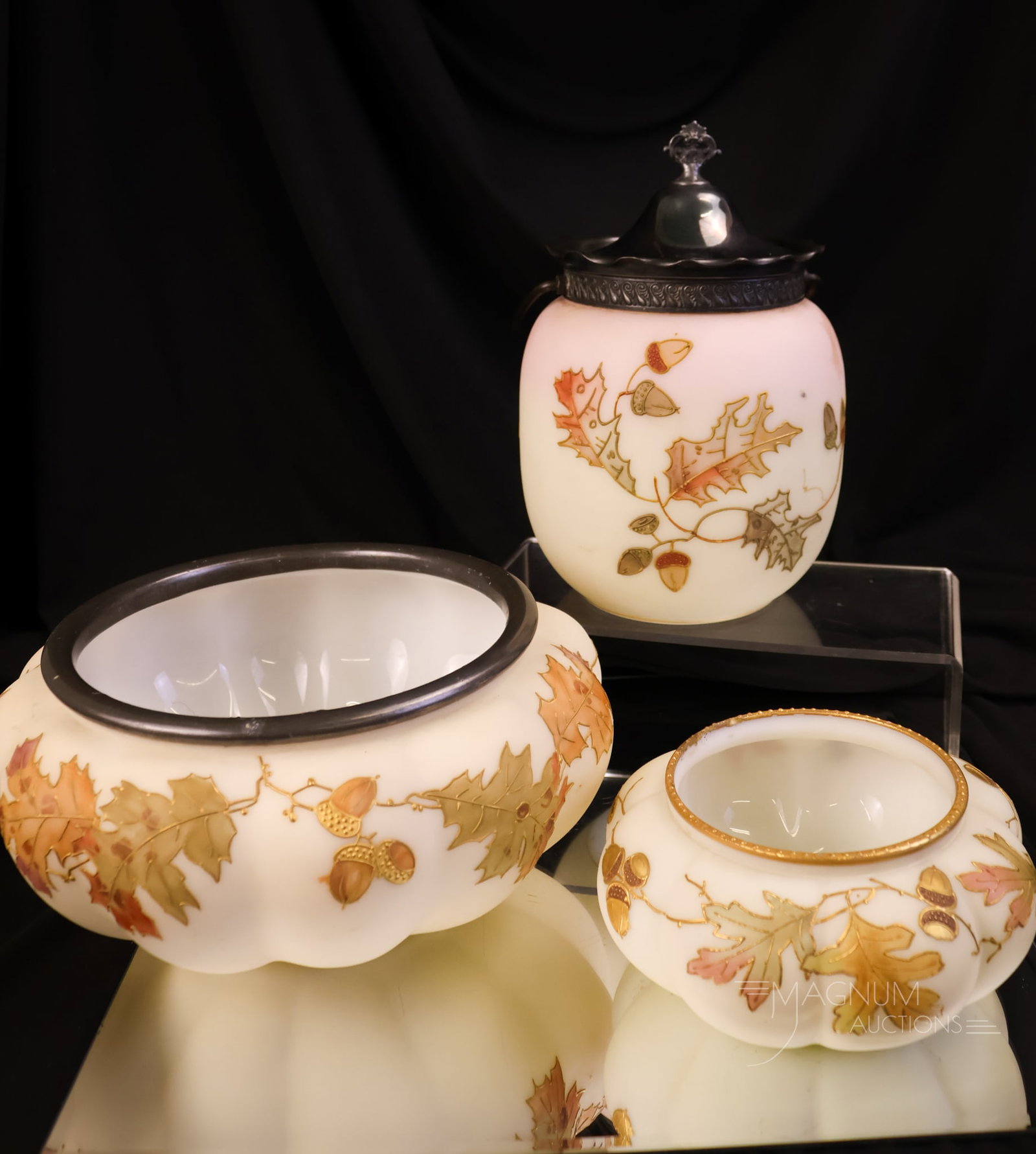 3 pc Lot Victorian Glass Smith Bros. & Mt. Washington Oak Leaf Decoration: Three oak leaves and acorns decorated pieces of Victorian glass. The first is a Mt. Washington biscuit jar. The second and third pieces are bowls. One is larger, with a silverplate rim, and a smaller.