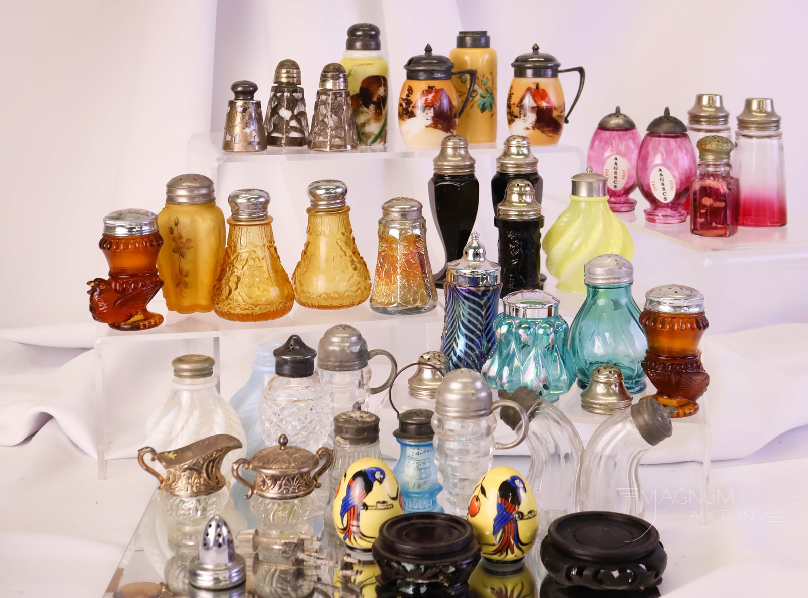 37 pc Lot Fenton Victorian & Contemporary Glass Salt Shakers: A more-than-generous lot of thirty-seven Victorian, Fenton, and contemporary glass shakers. In addition, there are three shaker lids, two salt agitators, and two wooden plinths. The tallest of the lot