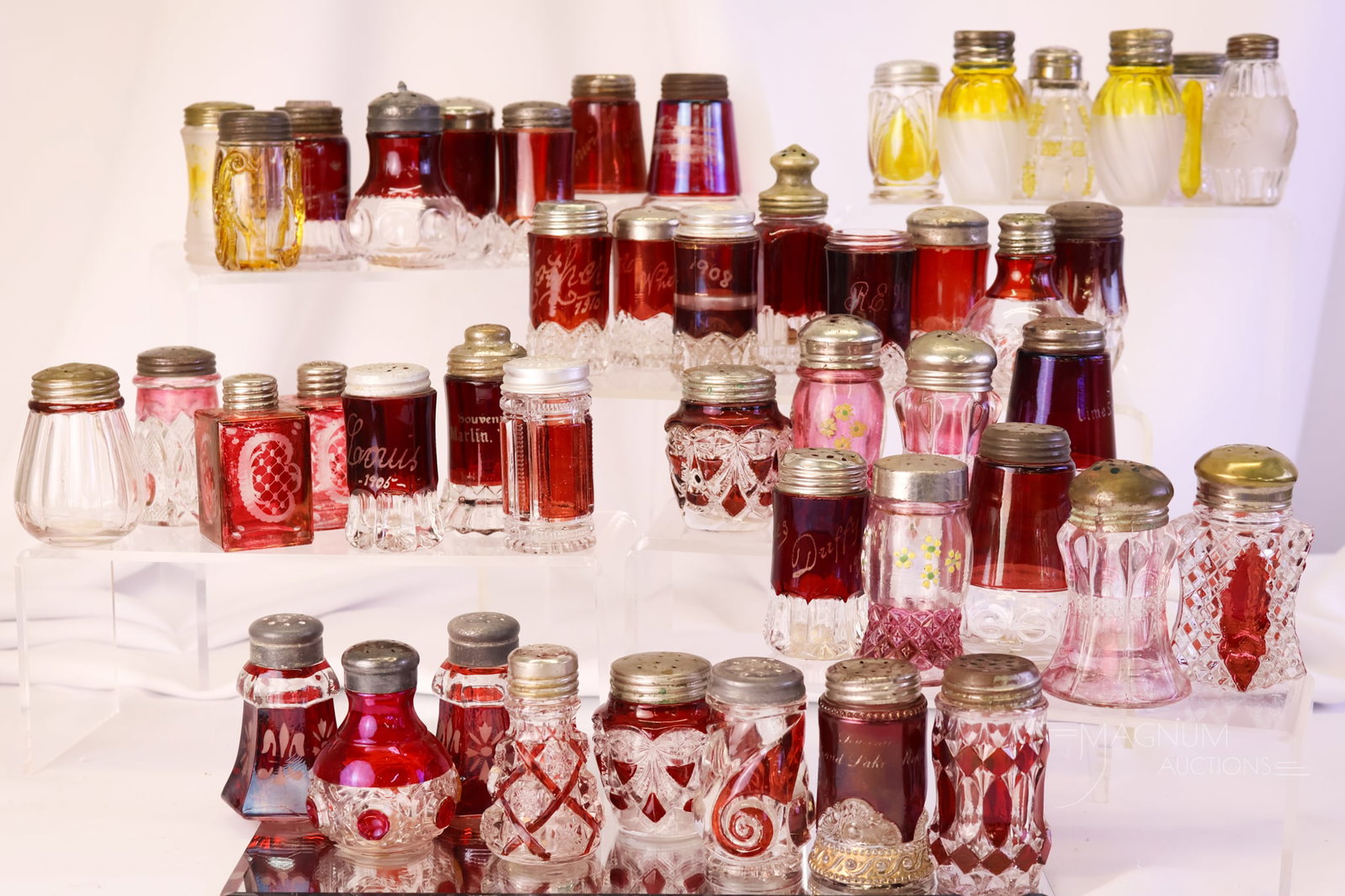 46 pc Lot Victorian Ruby Amber Rose Stained Glass Salt Shakers: A more-than-generous lot of Victorian stained-decorated salt shakers. This lot offers forty-six pattern glass shakers. Thirty-six are ruby-stained. There are seven pairs in this lot. There are also ei