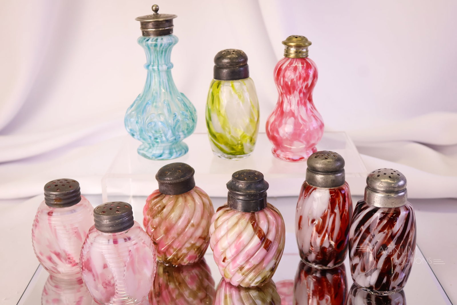 9 pc Lot Victorian Spatter Glass Salt Shakers: A lot of nine desirable and unusual spatter art glass salt shakers. These are in varying colors and forms. There's a unique blue and white in the mix. The tallest measures 4 1/2".