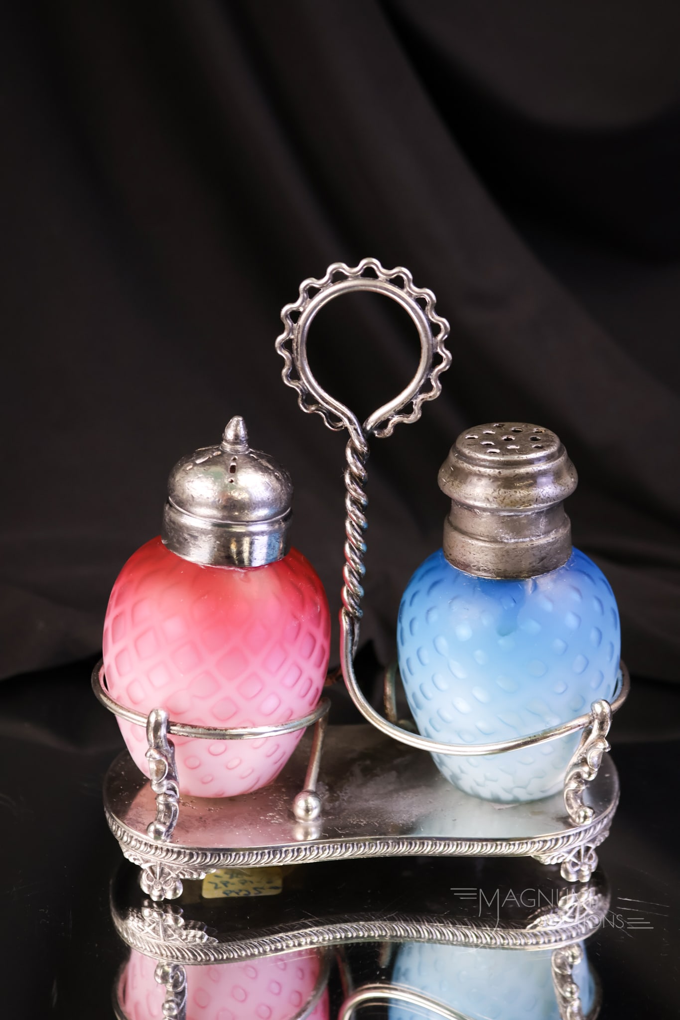 Victorian Mother of Pearl Satin Glass Salt Shaker Set Webster Silverplate: A Victorian mother-of-pearl diamond quilt satin glass set of shakers in a signed Webster Victorian silverplate holder. One shaker in pink and one in blue. The set measures 5" tall.