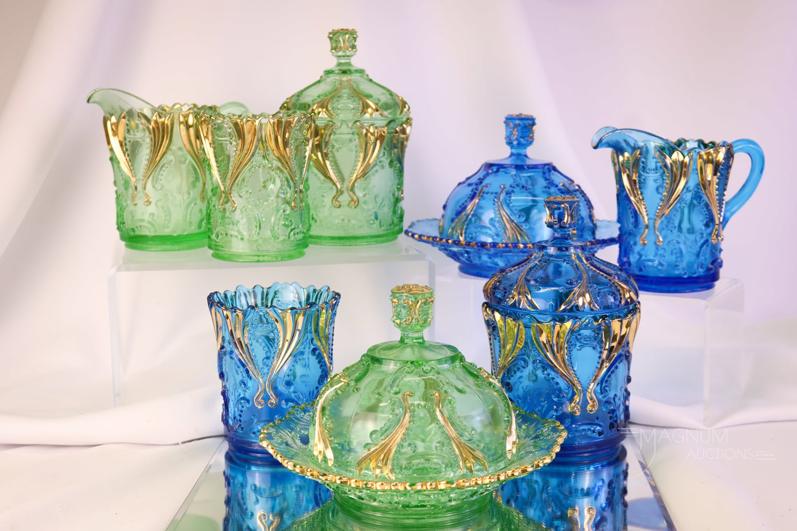 8 pc Lot Jefferson Victorian Glass Idyll Table Sets: Two complete table sets in Victorian Jefferson Glass Idyll pattern. One set is in blue with gold. The other is green with gold. Tallest measures 6".