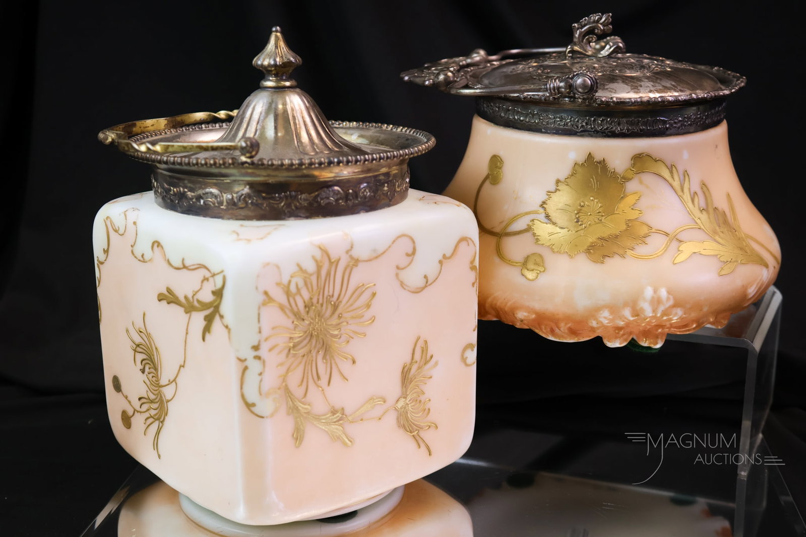 2 pc Lot Pairpoint Victorian Glass Mt. Washington Biscuit Jars: Two beautiful finds in Pairpoint Glass and marked Mt. Washington silverplate biscuit jars. The first is a square example with pink and white, with gold Fuji mums. The second jar has an all-over peach 