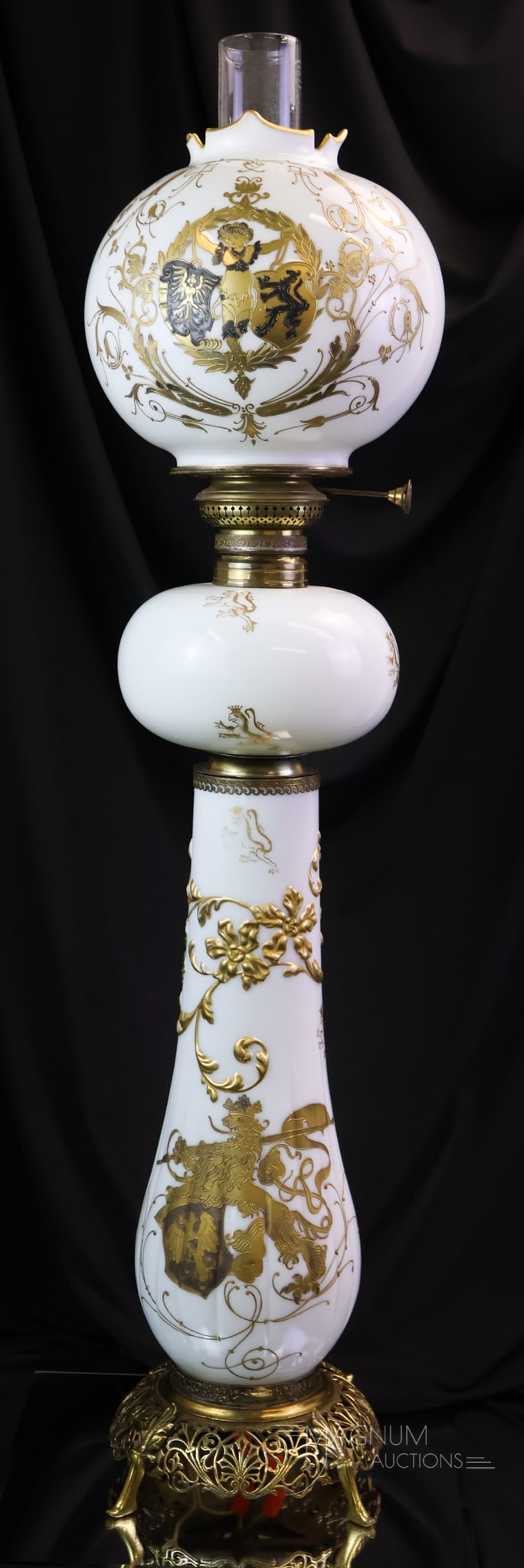 Mt. Washington Colonial Ware Lion & Shields Victorian Banquet Oil Lamp: A rare find in a Mt. Washington Victorian glass oil banquet lamp. This superb lamp measures 33 1/2" tall. It has magnificent decoration of a royal lion with a shield on the base. Lions on the font, an