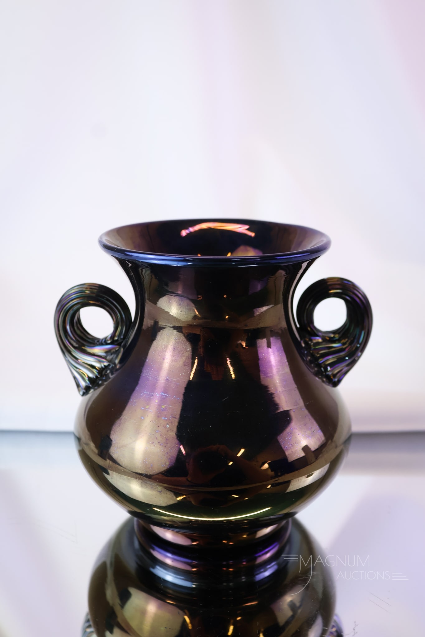 Rare Mt. Washington Bronze Double Handle Iridescent Art Glass Victorian Vase: A very rare find in Mt. Washington art glass. This is a "Bronze Ware" double-handle vase. Seldom are pieces of this glass seen. This iridescent glass vase measures 4" tall and 4 1/2" wide.