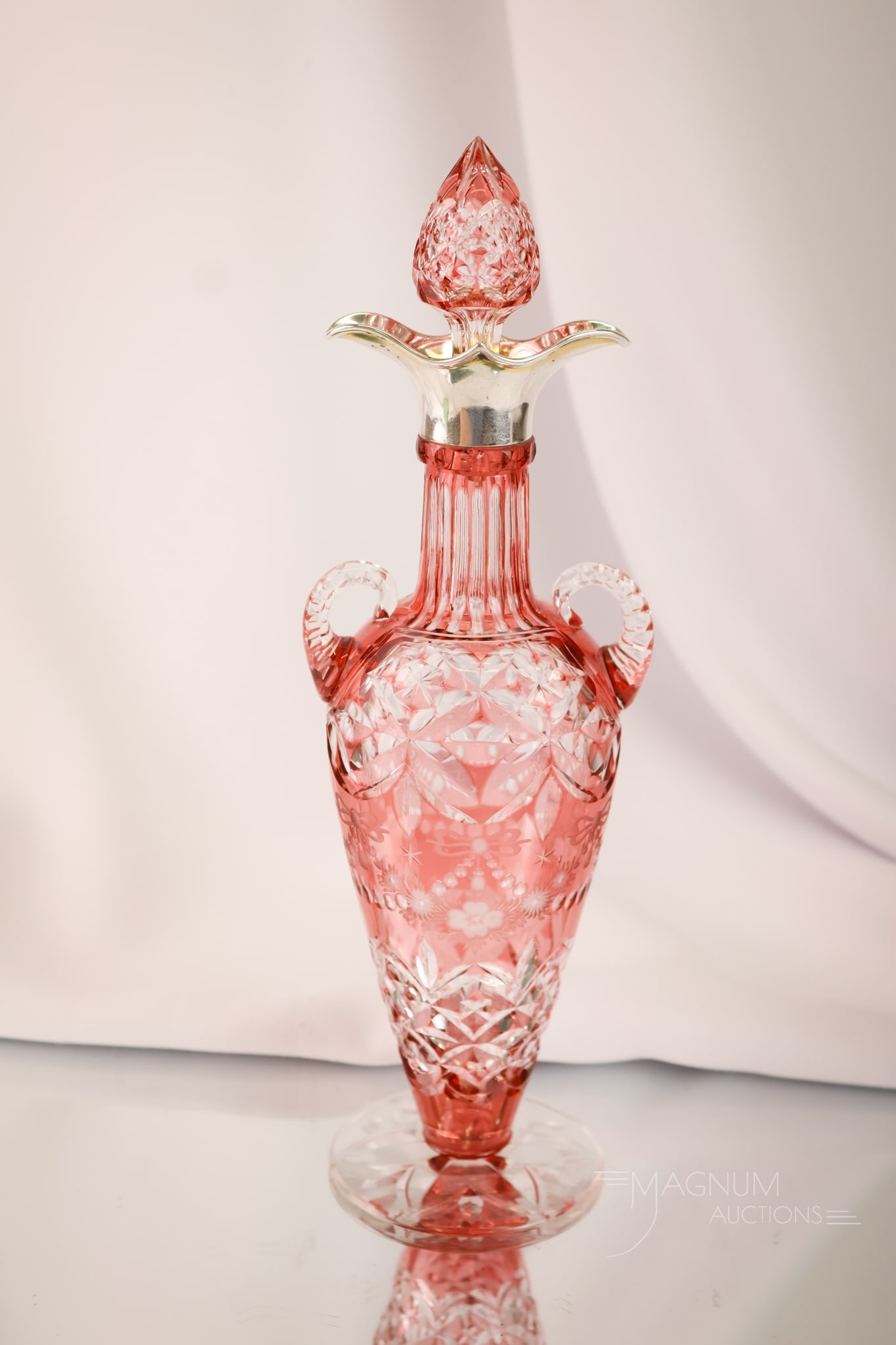 Stevens & Williams Victorian Hallmarked Sterling Perfume Cologne Decanter: A wonderful cranberry cut to clear Stevens & Williams cologne decanter. This piece features a hallmarked sterling rim. All-over delicate cutting. The piece measures 10 1/2" tall.