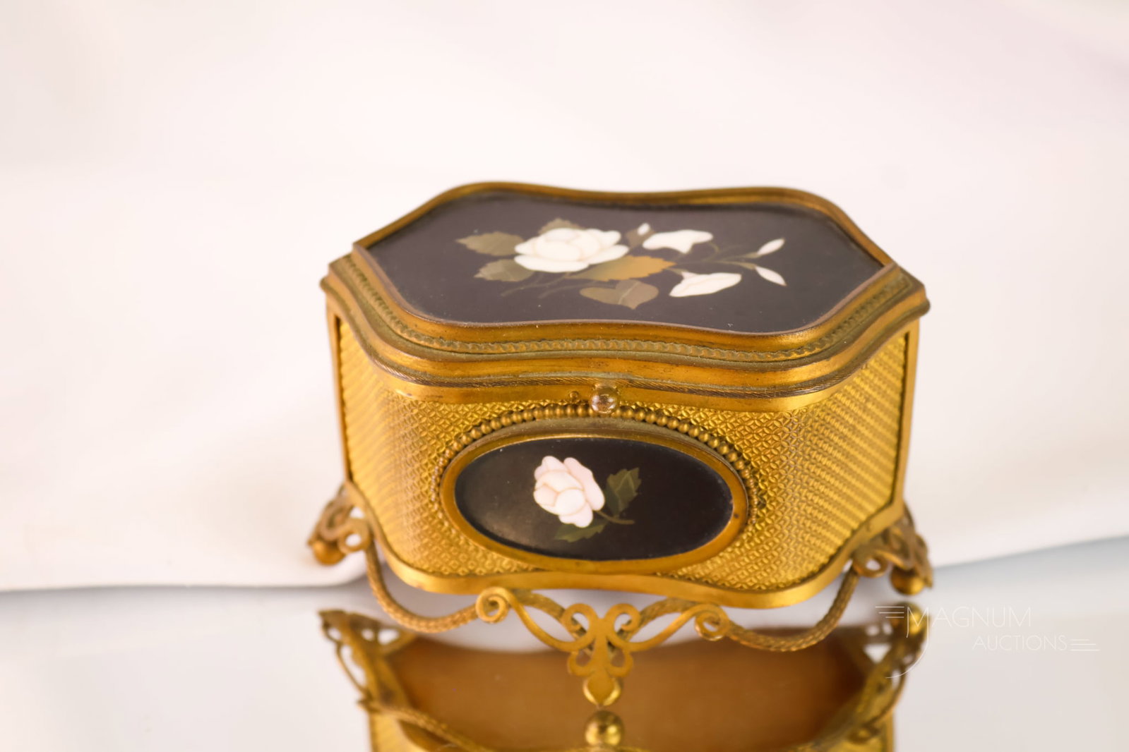 19th Century Italian Pietra Dura Gilt Bronze Silk Lined Jewelry Box: A gorgeous Italian Pietra Dura gilt bronze jewelry box. This fine example features three panels with roses. It is lined with silk. The box measures 2 1/2" tall and 4" wide.