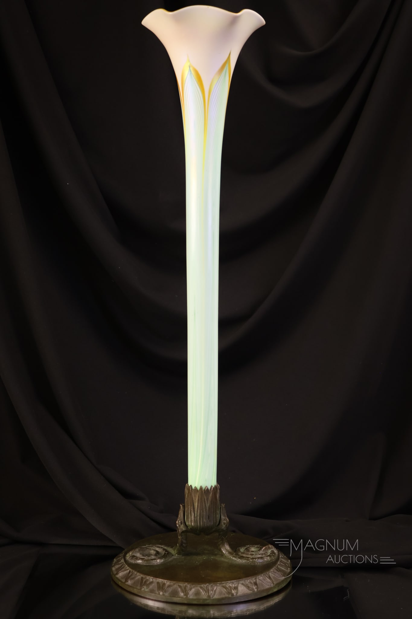 Quezal Pulled Feather 20" Vase in Bronze Holder: A beautiful and sleek find in Quezal art glass and bronze. This is a 20 1/4" tall vase with a green iridescent pulled feather design vase mounted in a bronze base.