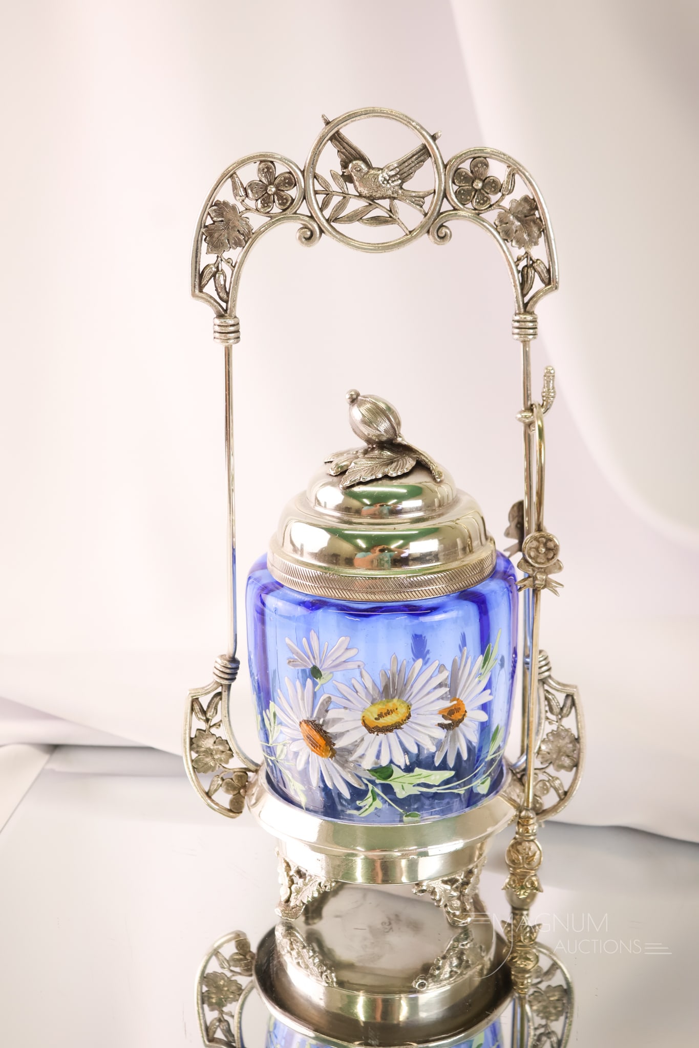 Victorian Silverplate Blue Enamelled Glass Pickle Castor: A wonderfully attractive Victorian silverplate and glass pickle castor from the Gilded Age. This castor has an ornate frame with a blue ombre glass and enamelled flowers. The castor measures 11" tall.