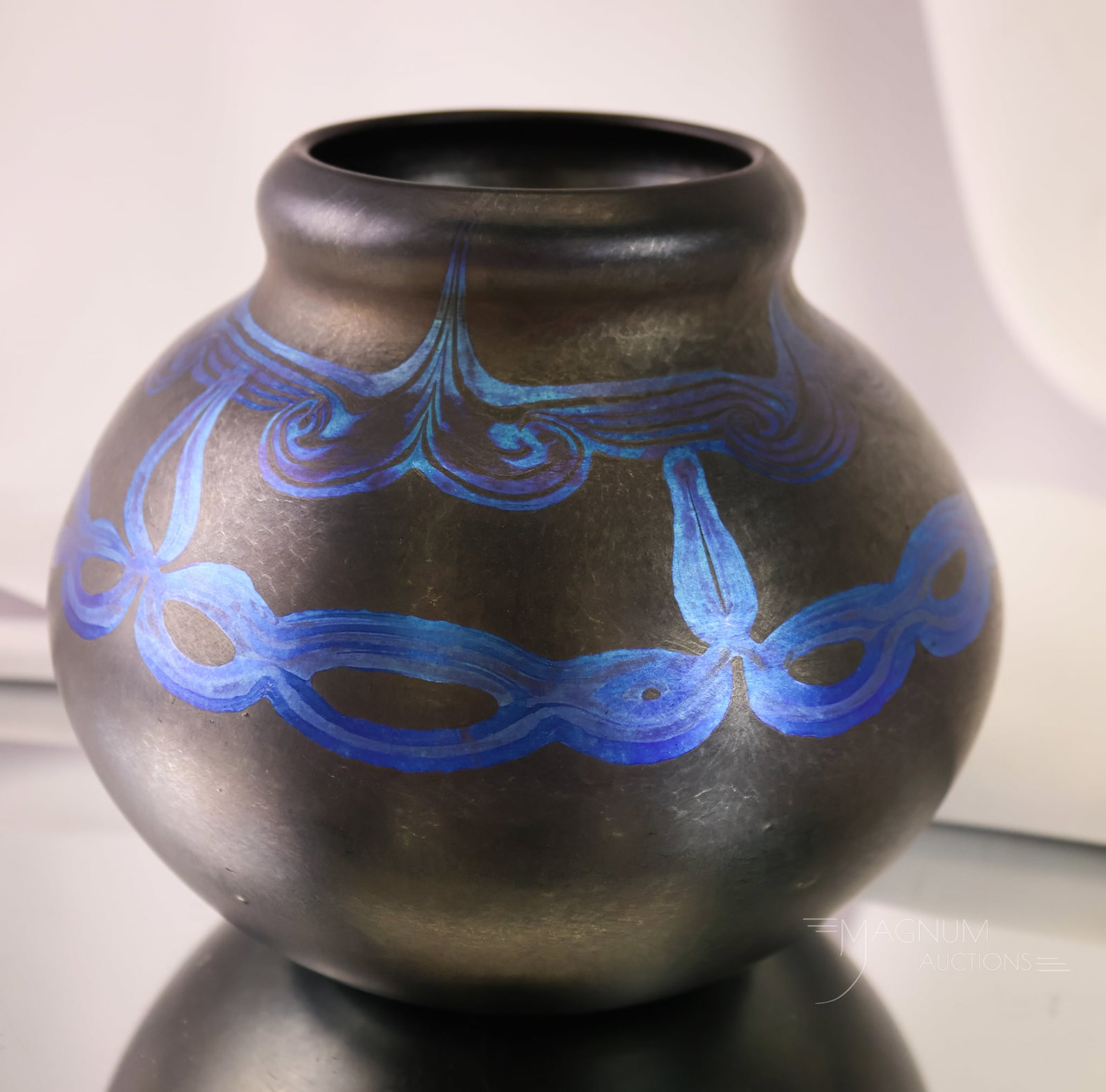 Rare Tiffany Black Favrile Decorated Glass Vase: A beautiful and rare find in Tiffany glass. This piece is signed, "L.C.T. Tiffany Favrile, 9892." The vase is in black Favrile with electric blue designs. The vase is 5" tall and 6" wide.