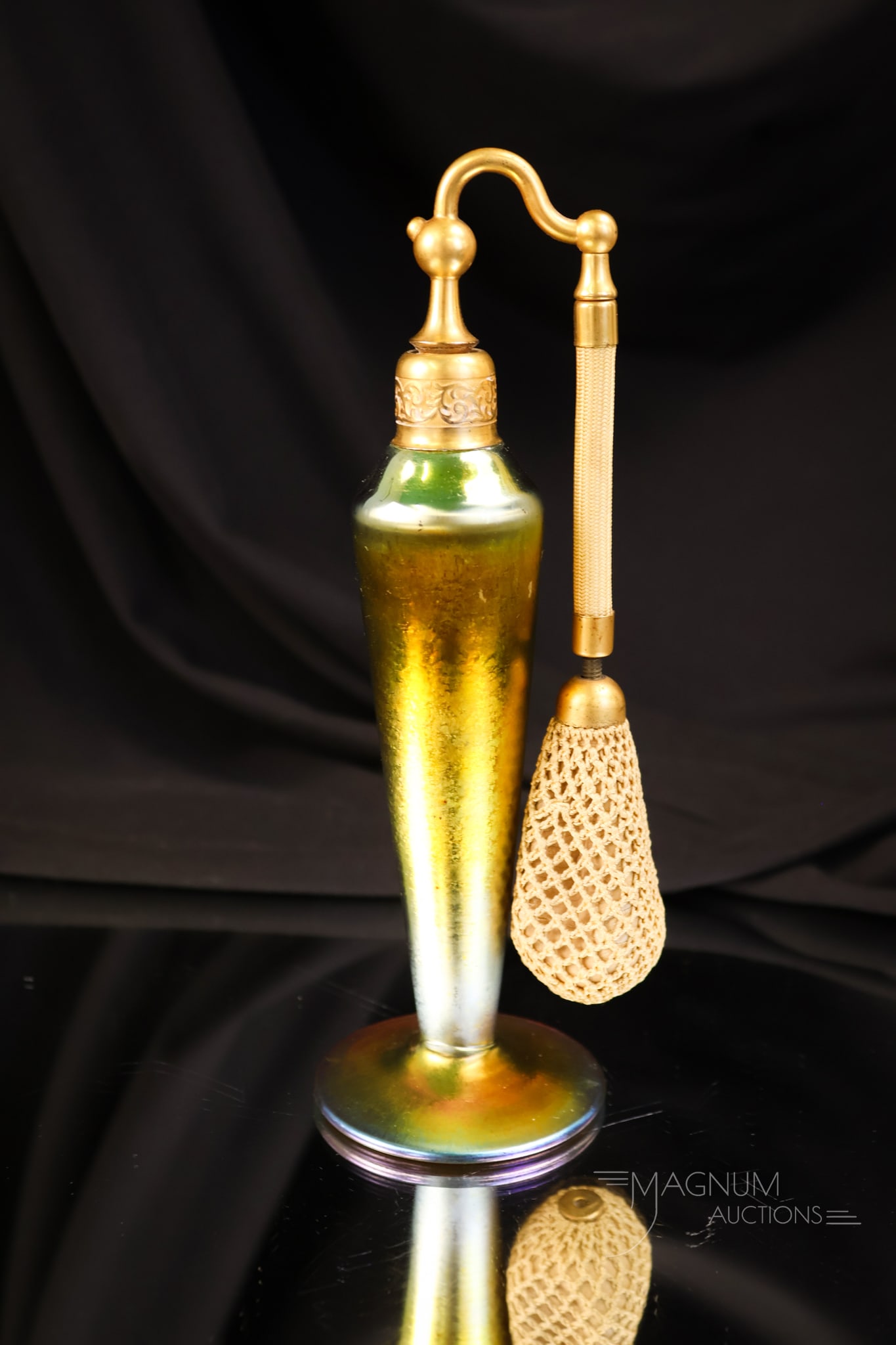 Steuben Gold Aurene Art Glass Perfume Atomizer: A wonderful gold iridescent Aurene perfume atomizer by Steuben. This lovely example measures 7 1/4" tall and 2 1/4" wide. The bulb has hardened over time