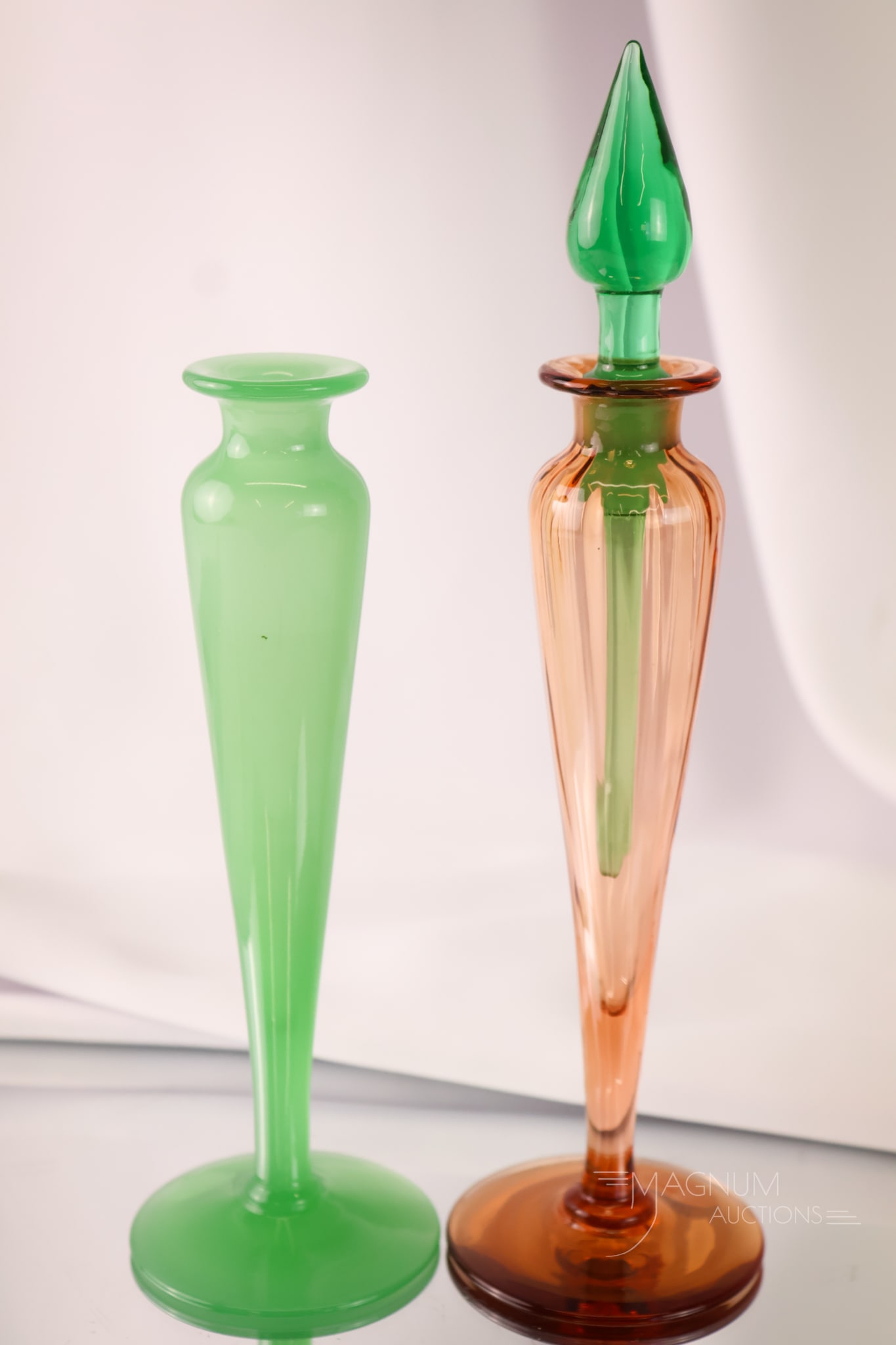 2 pc Lot Steuben Art Glass Perfume Bottles Jade Green & Rosa Pink w/ Pomona: A select offering of two Steuben Perfume Bottles for parts. The first is a jade green lacking a stopper. The second is a rosa pink with a Pomona green stopper with a full dauber. The tallest measures