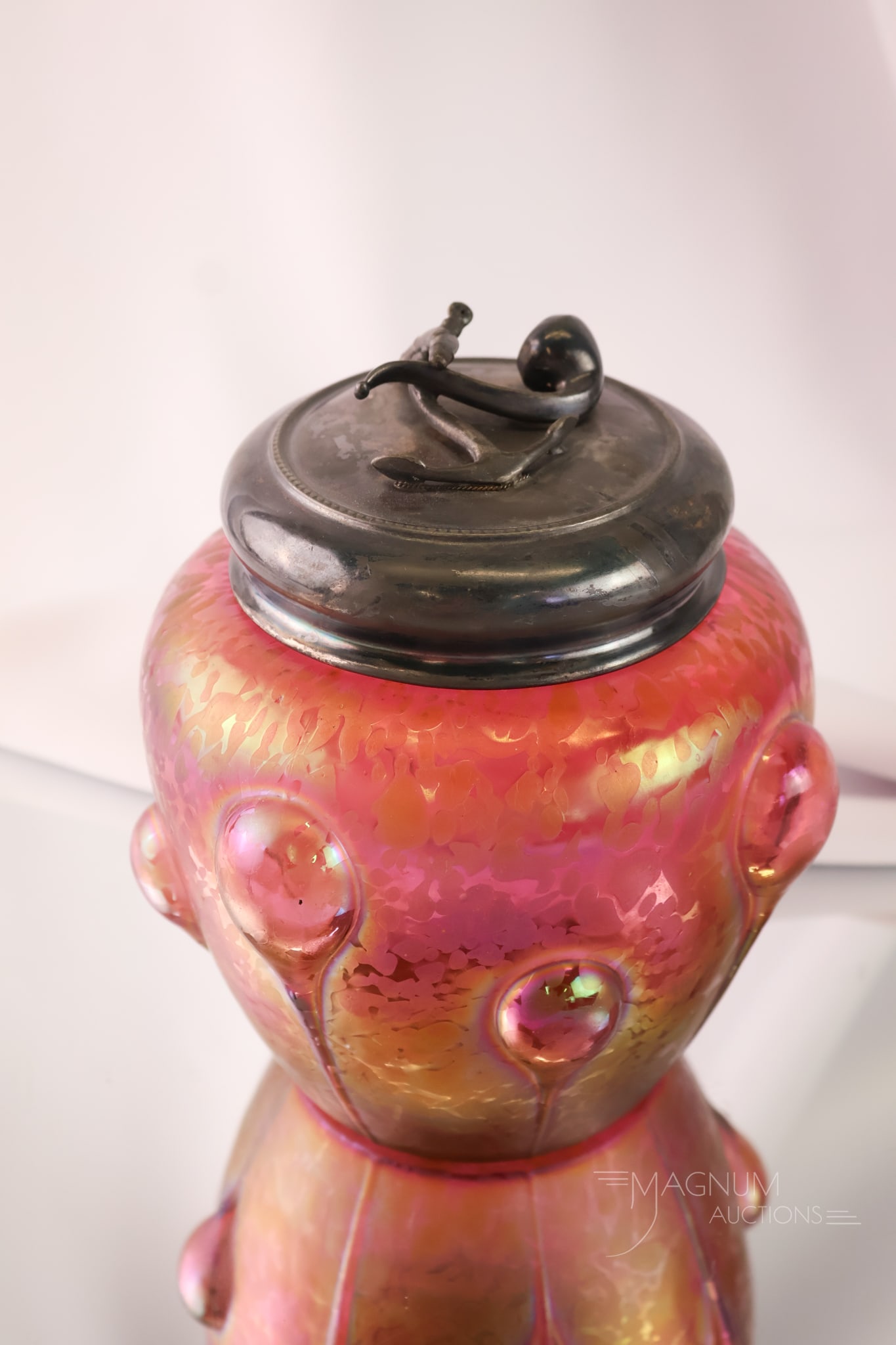 Austrian Red Iridescent Oil Spt Applied Glass Silverplate Humidor: A striking red iridescent oil spot Austrian humidor. This piece has applied large tadpole decoration. The lid is silverplate with an anchor and a pipe. The piece measures 7" tall and 6" wide.