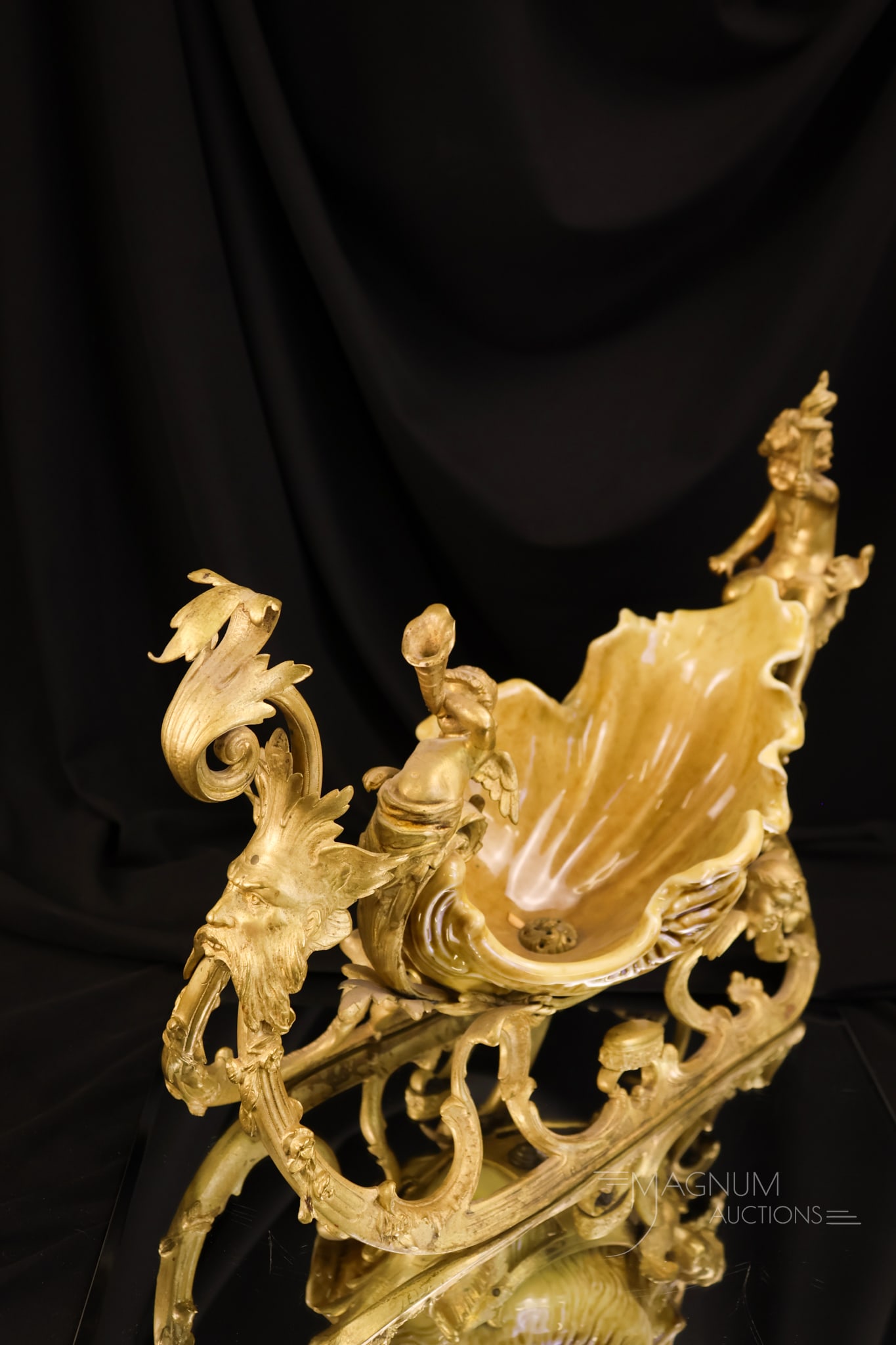 Continental Yellowware Sleigh with Cherubium & Bronze Adornments: A beautiful find in continental yellowware. This is in the form of a sleigh. The piece is decorated with cherubim. It features gilt bronze metal adornments. The piece measures 11" tall and 15" wide.