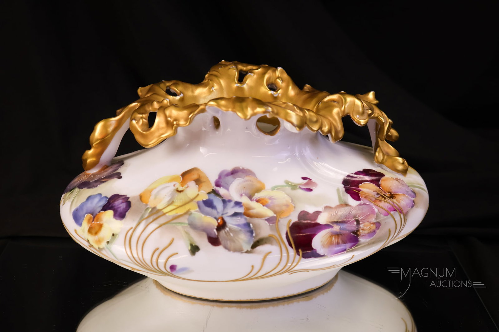 Pairpoint Limoges Porcelain Pansy Decorated Vase: A beautiful example of Pairpoint Limoges porcelain. This vase with an unusual form is decorated with colorful pansy flowers and a gold rim. The vase measures 5" tall and 8 1/2" wide.