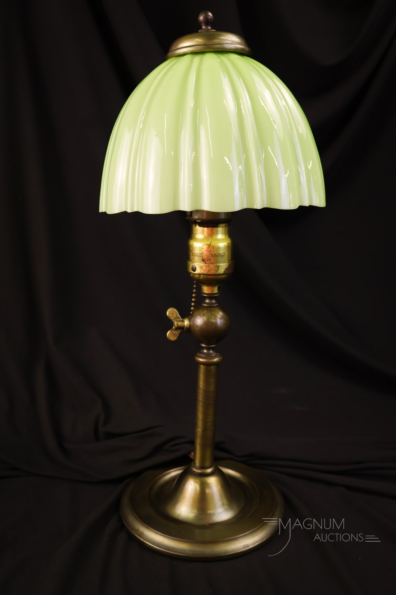 Antique Green Cased Adjustable Desk Lamp: A very attractive celery green-cased antique table lamp. This fine piece features a scalloped shade in celery green cased glass. The base is adjustable. The lamp measures 10" tall.