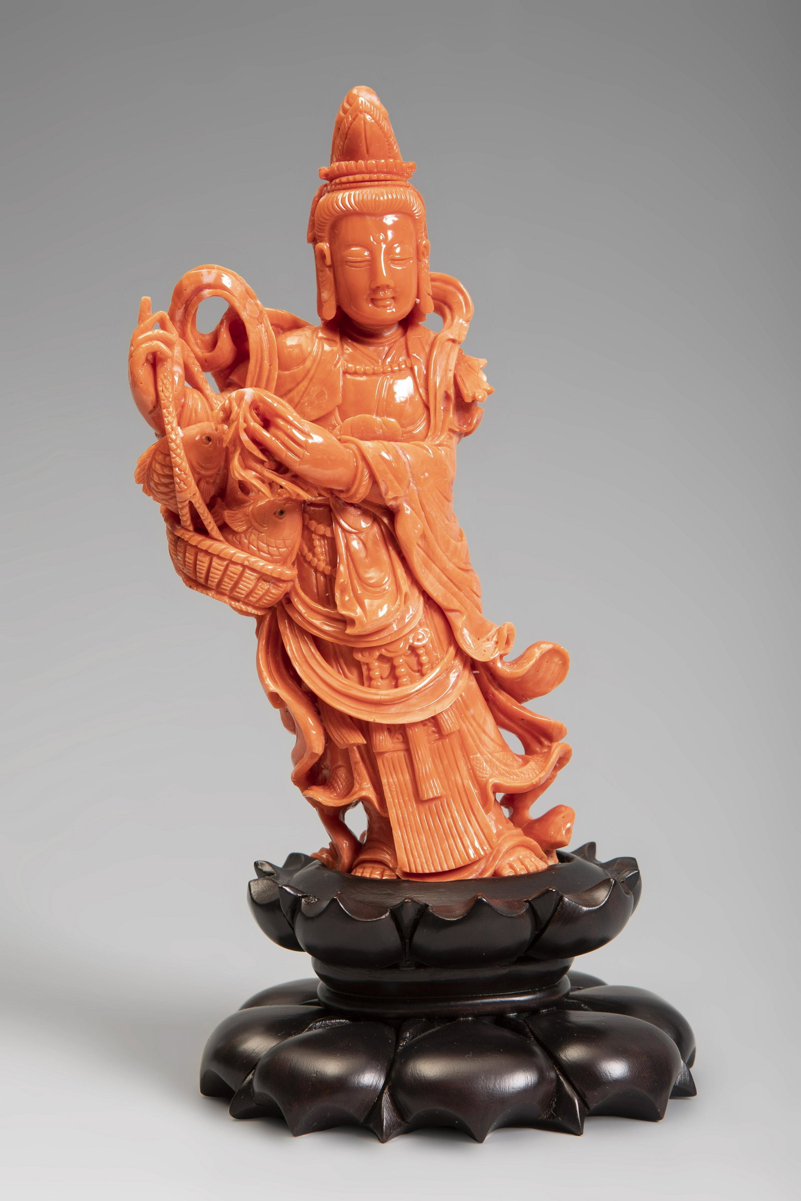 Guanyin from Southeast Asia, 20th century. Coral.: Guanyin from Southeast Asia, 20th century.Coral.Base in carved wood.Weight: 418 gr.Measurements: 15 x 8 x 7 cm (without base); 19.5 x 10 x 8 cm (with base).From the physical and formal characteristics
