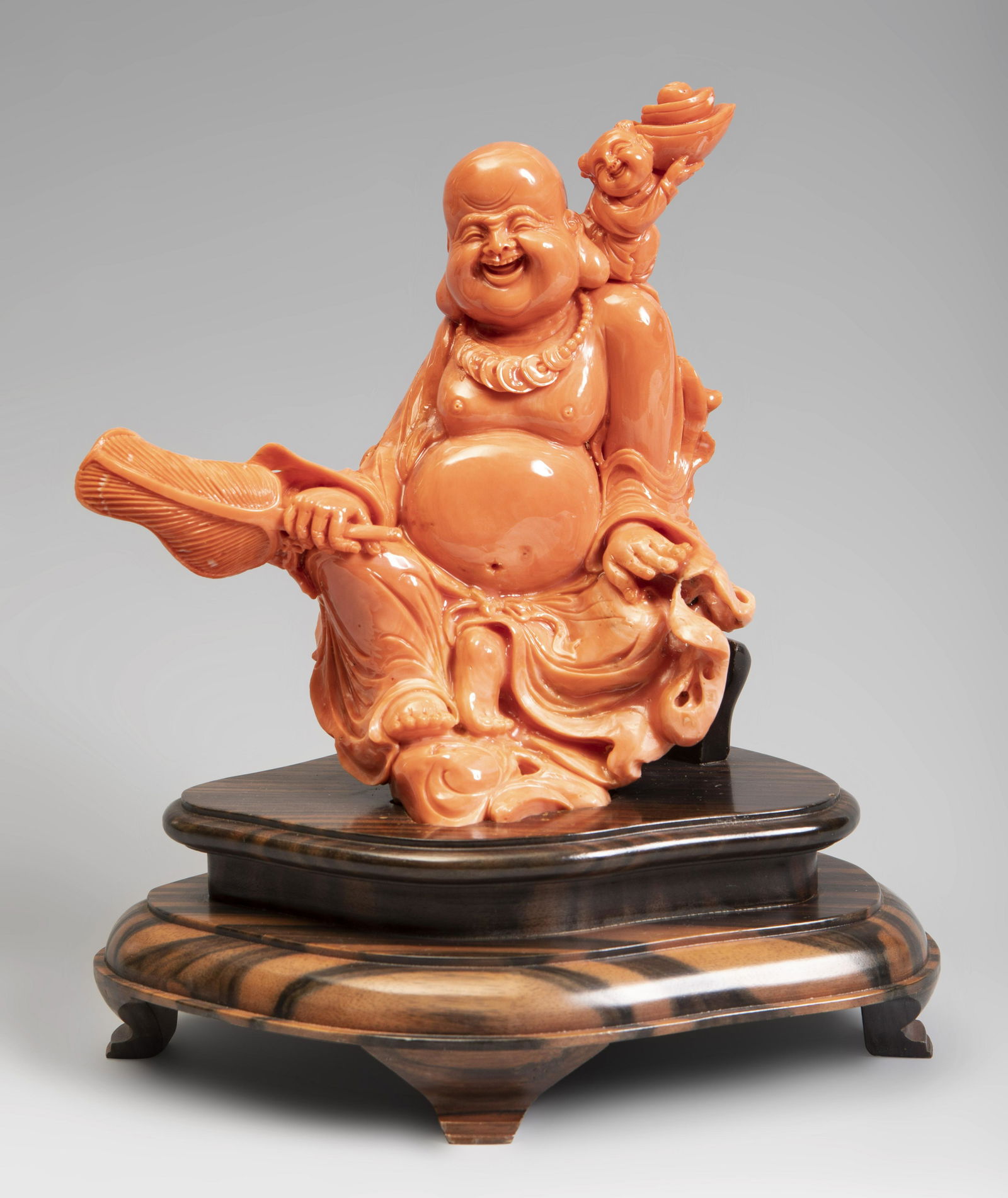 Smiling Buddha. China, 20th century.  Coral.  Wood (1 of 3)