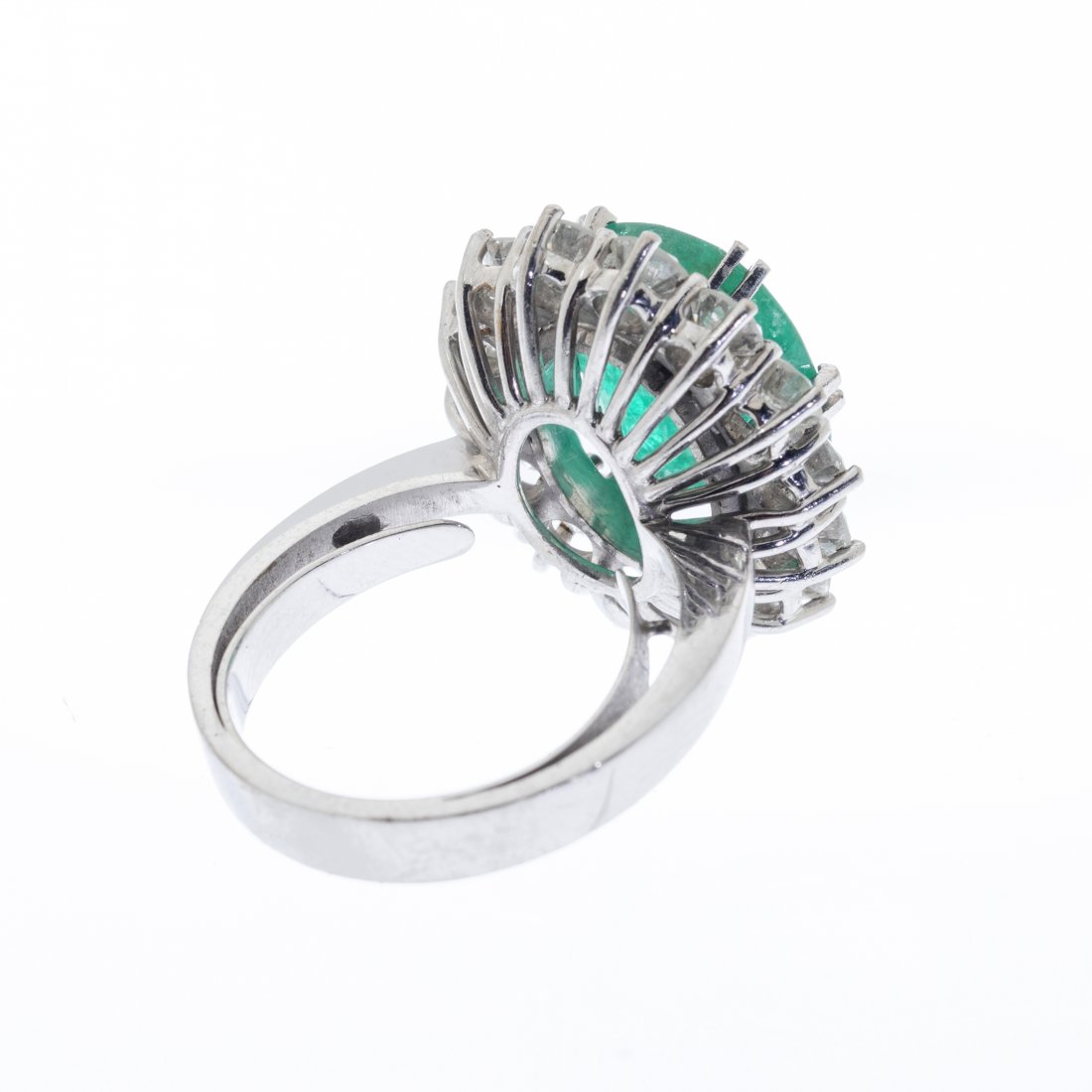 Ring rosette in 18 kts: Ring rosette in 18 kts. white gold. With central emerald, oval cut, intense green color, weighing ca. 5.00 cts. and bordered by diamonds, brilliant cut, color I / J, purity SI and total weight ca. 1.7