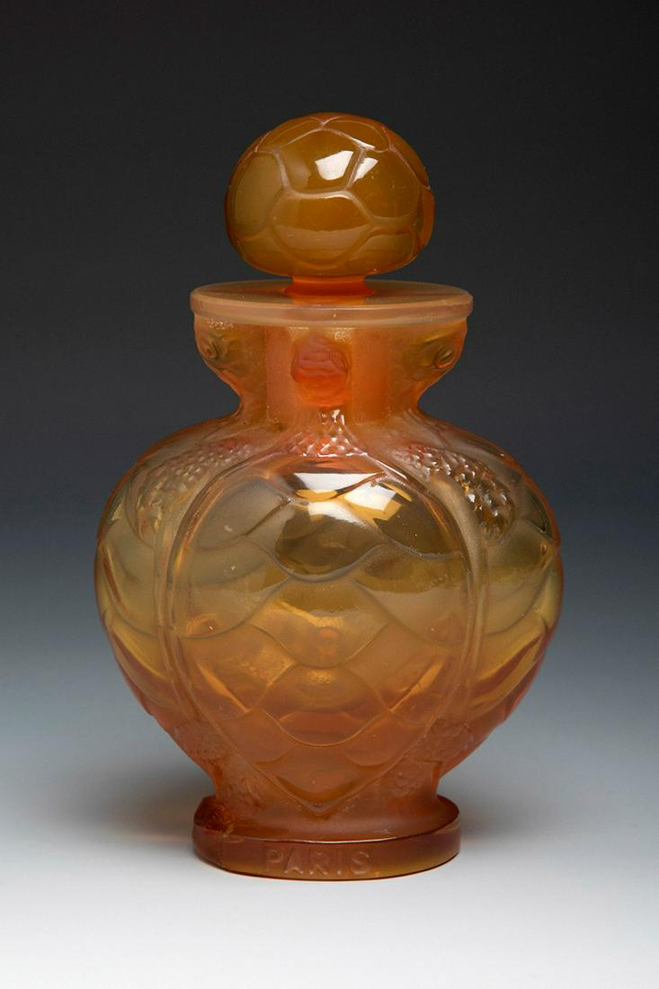 MARC LALIQUE (Paris, France, 1900 - 1977). Perfume bottle "Morabito nÂº 7". 1950s. Caramel-coloured: MARC LALIQUE (Paris, France, 1900 - 1977). Bottle for perfume "Morabito nÂº 7". 1950s. Caramel-coloured moulded glass. Signed on the back of the base Lalique France. Slight restoration on the base.
