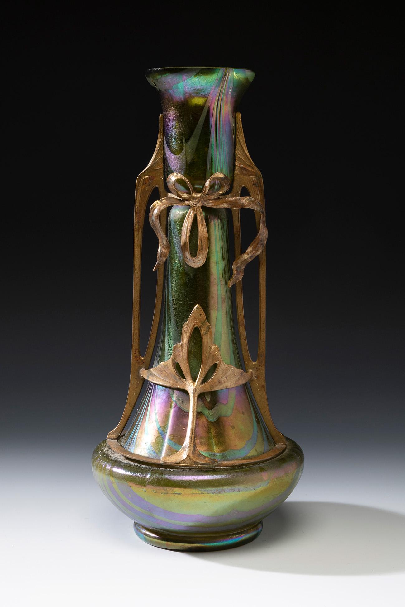 Jugendstil LOETZ vase; Austria, ca. 1900. Iridescent blown glass. An iridescent blown glass vase: Jugendstil LOETZ vase; Austria, ca. 1900. Iridescent blown glass. An iridescent blown glass vase from the Austrian manufactory of Loetz, with a flared body and circular lower part and mouth. Phaenomen