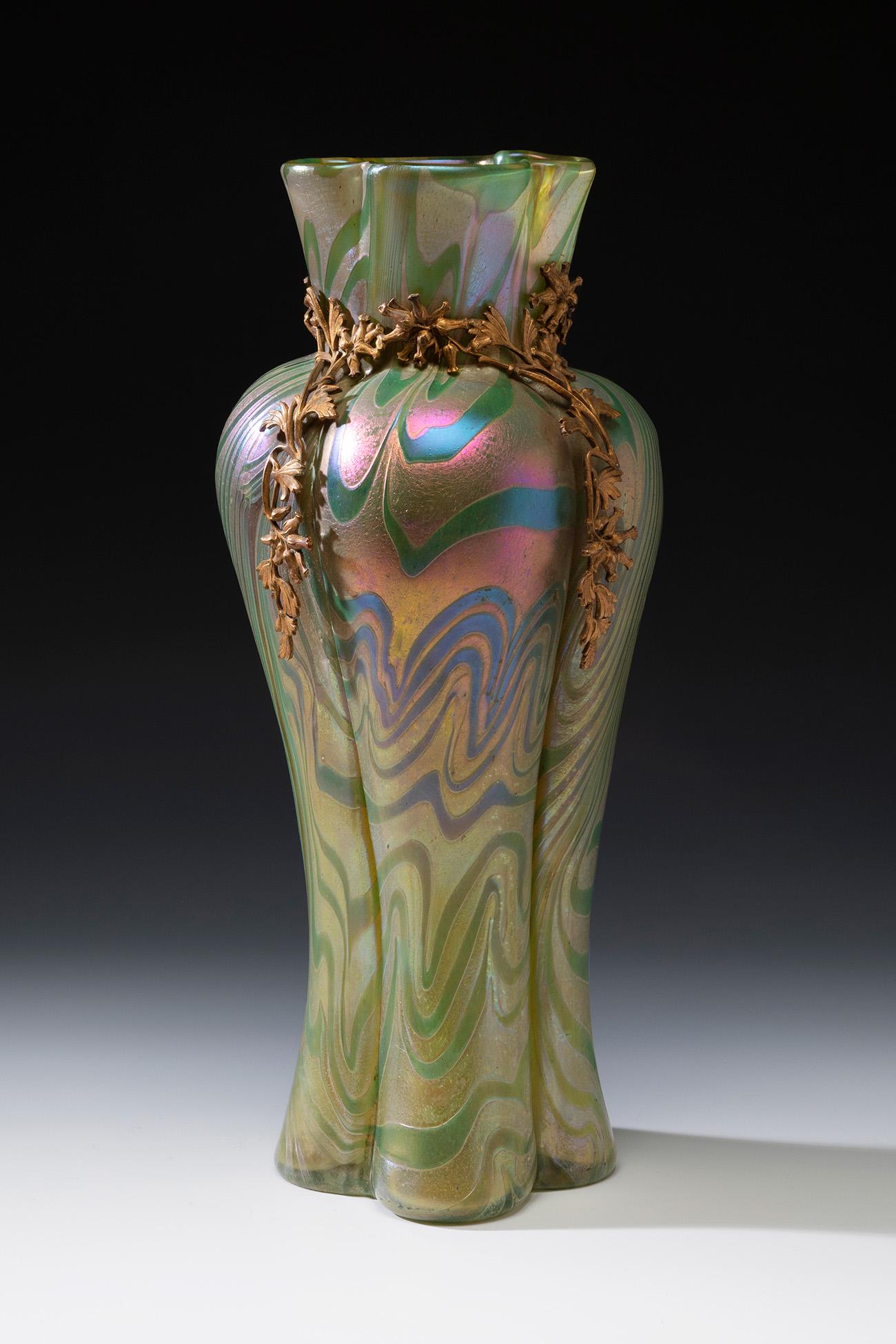 Jugendstil LOETZ vase; Austria, ca. 1900. Iridescent blown glass. An iridescent blown glass goblet: Jugendstil LOETZ vase; Austria, ca. 1900. Iridescent blown glass. An iridescent blown glass goblet vase from the Austrian Manufacture of Loetz, with a body in tapering lobed forms with a wavy mouthpie