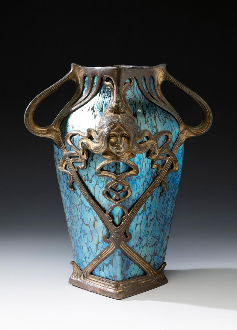 Jugendstil LOETZ vase; Austria, ca. 1900. Iridescent blown glass. An iridescent blown glass vase: Jugendstil LOETZ vase; Austria, ca. 1900. Iridescent blown glass. An iridescent blown glass vase from the Austrian Manufacture of Loetz, with a square-shaped body with slightly curved sides. Decoratio
