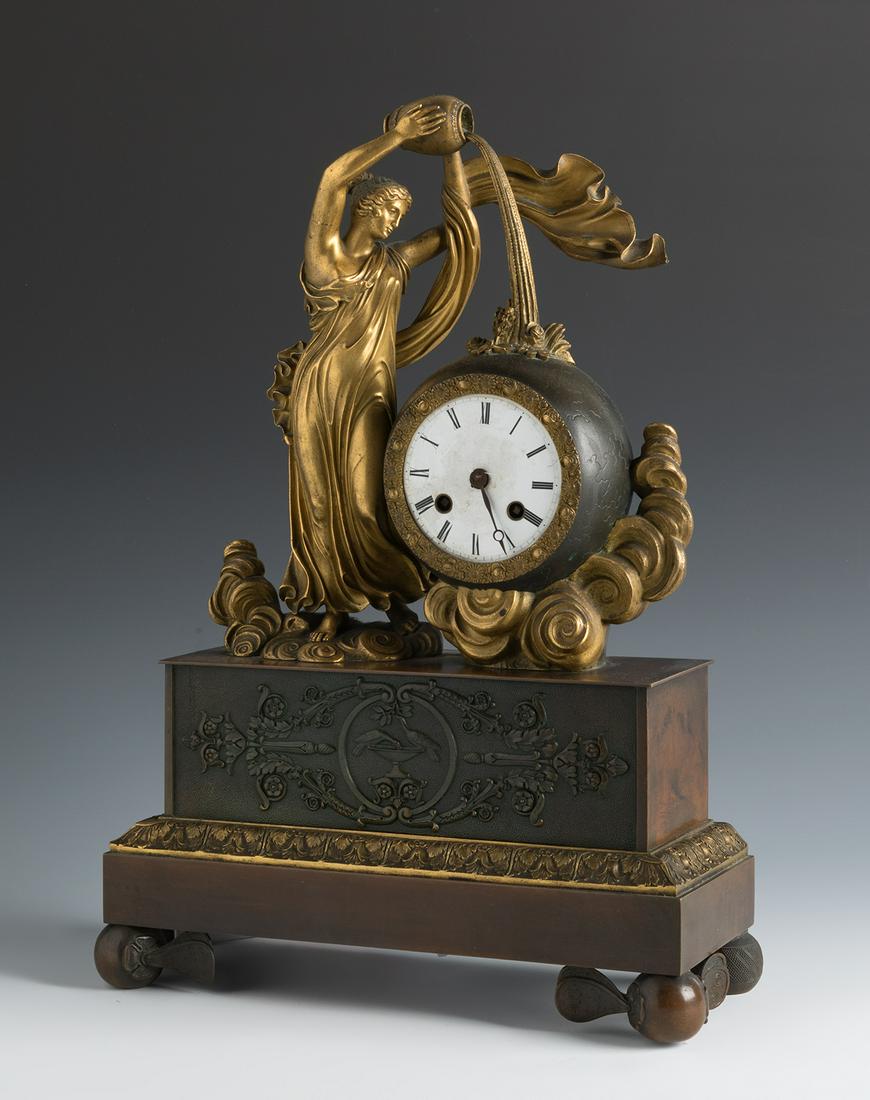 Empire table clock. France, early 19th century.  Patinated and gilded bronze. In need of (1 of 4)
