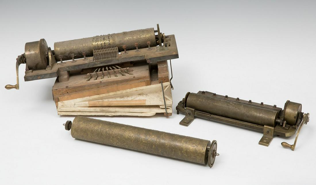 Set of two mechanisms with musical rollers; and a roller from the 19th century. Gilded iron, bronze: Set of two mechanisms with musical rollers; and a roller from the 19th century. Gilded iron, bronze and brass. Measuress: 20 x 44 x 24 cm; 7x33x19cm; 37 x 6cm.