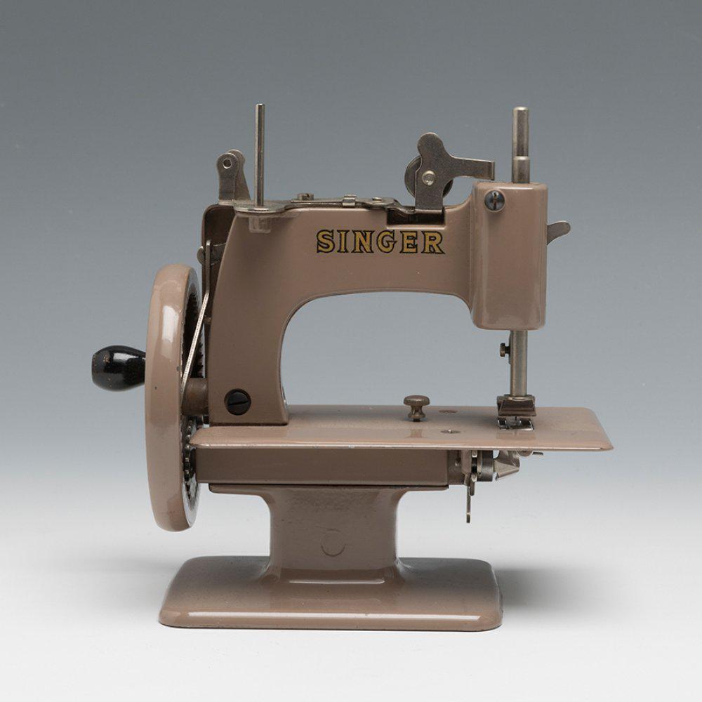 SINGER sewing machine. United States, 1950s-60s. Gray lacquered iron and metal. With Singer stamp.: SINGER sewing machine. United States, 1950s-60s. Grey lacquered iron and metal. With Singer stamp. Measurements: 17 x 18 x 8 cm. The mechanism is operated by moving the crank at the back. Sewing machi
