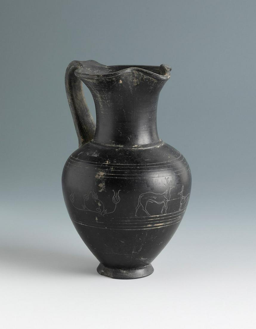 Oinochoe of the Etruscan culture. Central Italy, third quarter of the VII century BC. Black pottery: Oinochoe of Etruscan culture. Central Italy, third quarter of the 7th century BC. Black pottery from Bucchero. Certificate enclosed. Measurements: 18 cm (height). Black Bucchero pottery made on the po