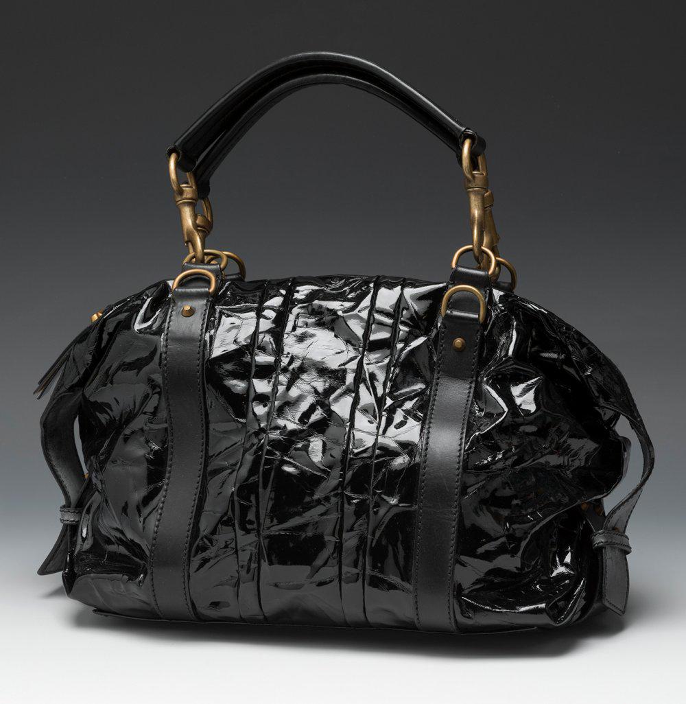 ESCADA. Black patent leather handbag with black leather details. Short non-adjustable handles: ESCADA. Black patent leather handbag with black leather details. Short non-adjustable handles connected to the body of the bag by golden carabiners. Zipper closure. Brown cotton lining. Slight marks o