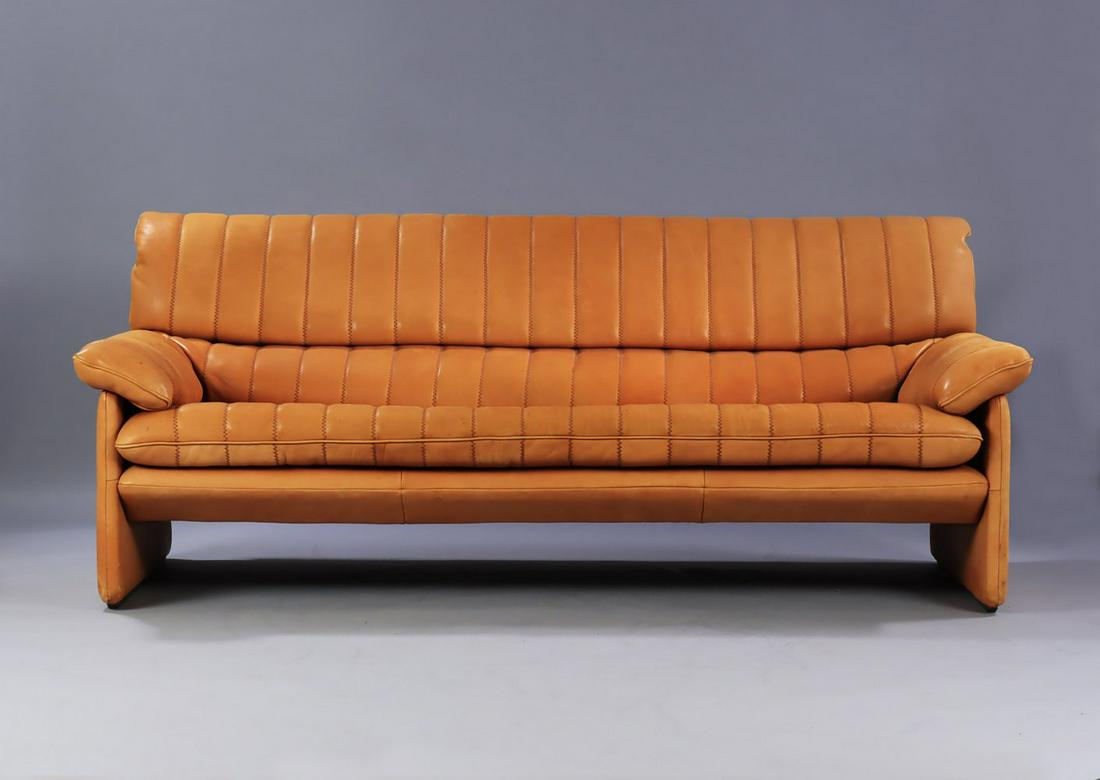 DE SEDE. Vintage three-seater sofa, model DS 86. Upholstered in cognac patinated natural leather.: FROM HEADQUARTERS. Vintage three-seater sofa, model DS 86. Upholstered in cognac coloured patinated natural leather. Made in De Sede, Switzerland, with logo on the lower fabric. It shows general age-r